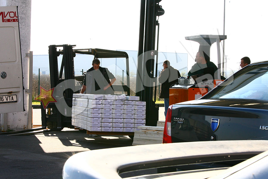 Dupa ce a verificat marfa, angajatii incarca parchetul in duba Voltaj