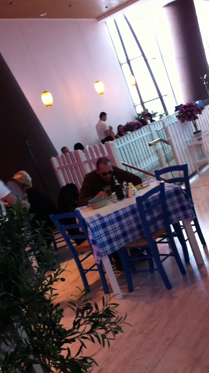 Oreste se aseaza si incepe sa manance tacticos din preparatele grecesti