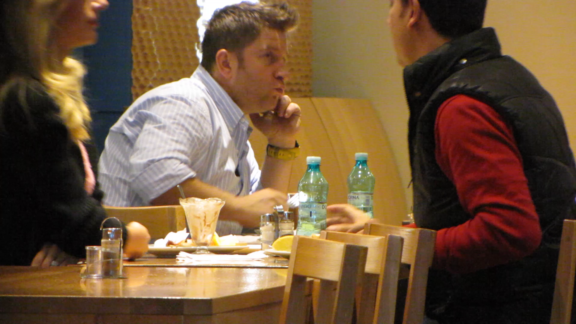 Pavel Bartos se aseaza la masa si incepe sa manance in timp ce vorbeste la telefon