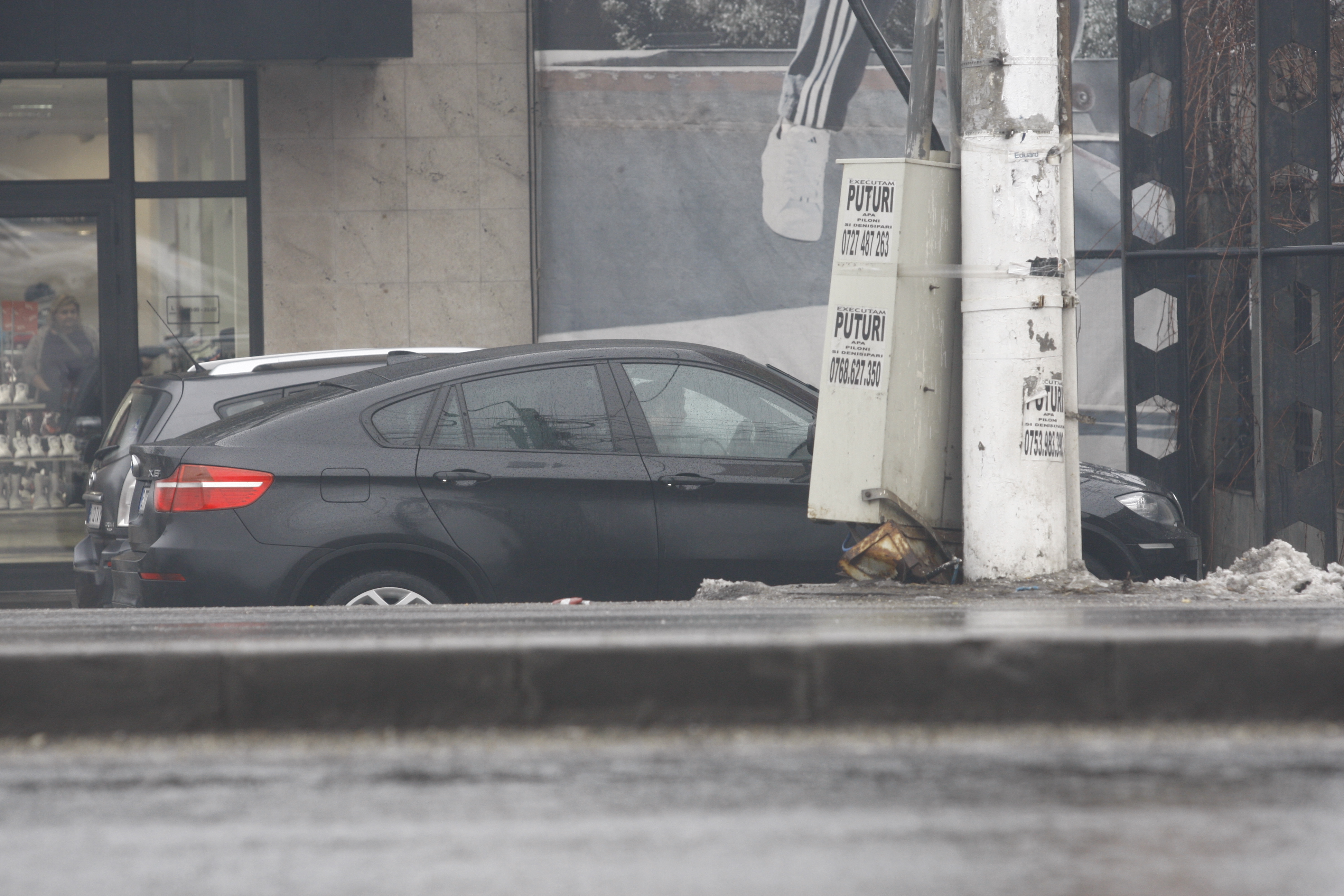 Bruneta si copilul ei incarca pungile in portbagajul masinii