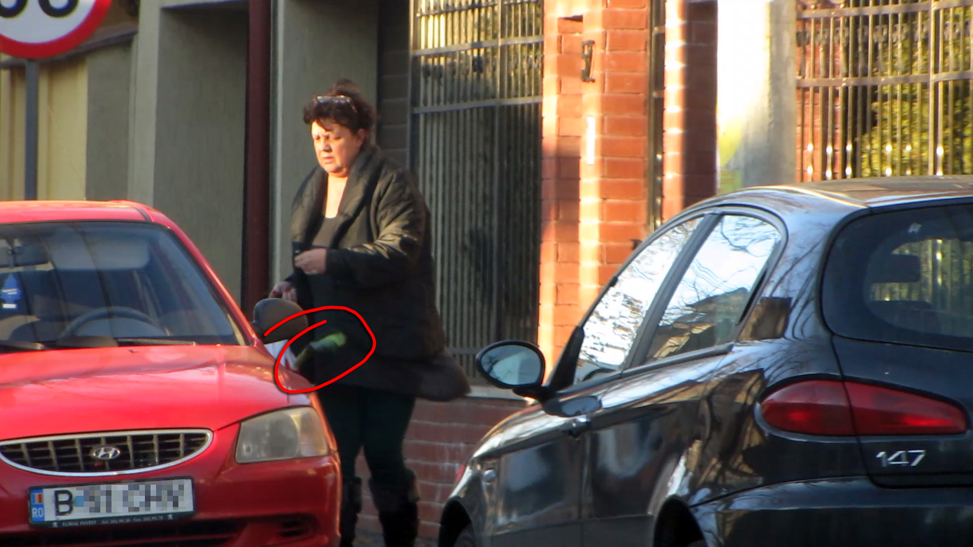 Femeia scoate din masina o sacosa din care se iteste coada lunga a unui praz
