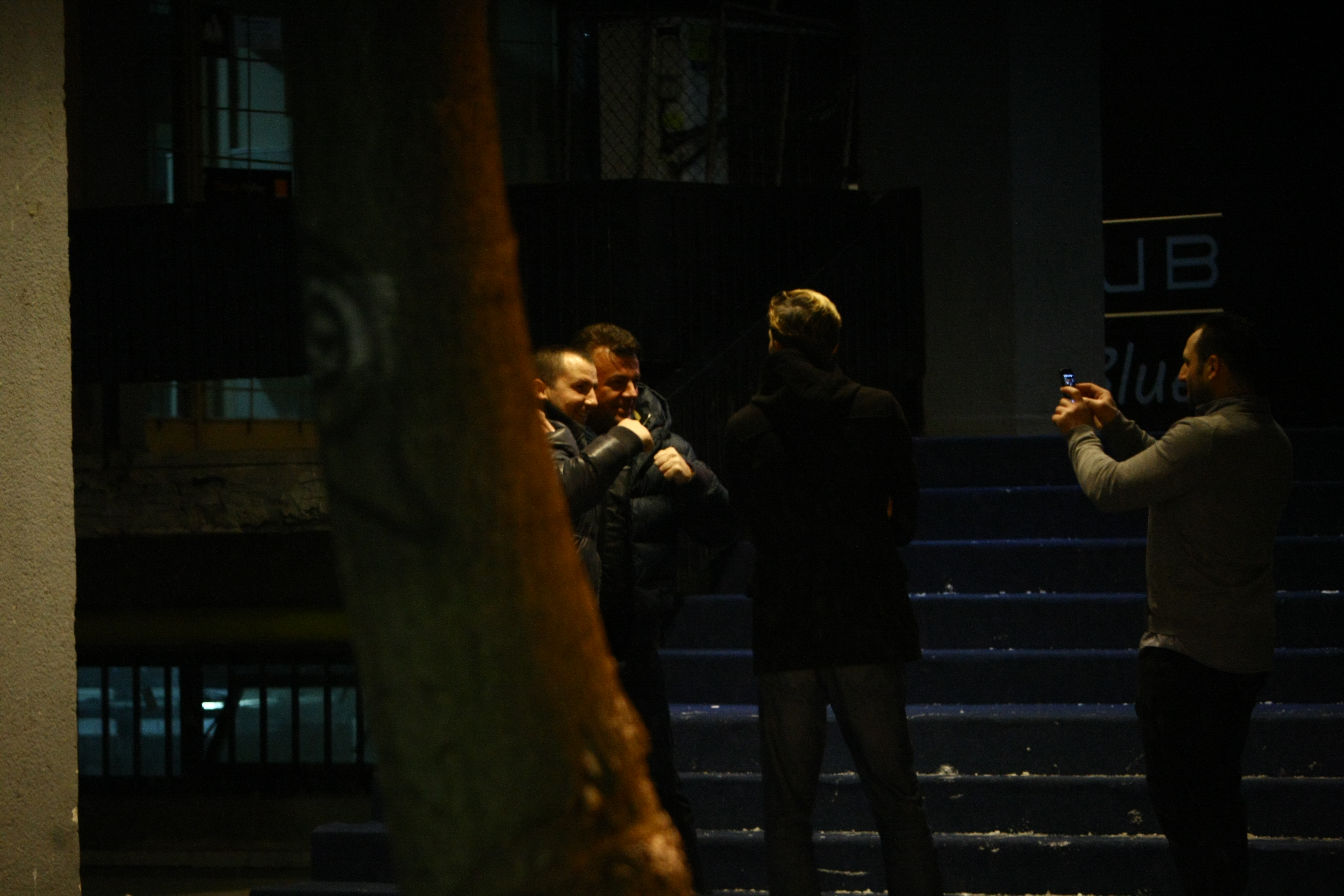 Impreuna cu un amic, artistul face poze in fata clubului