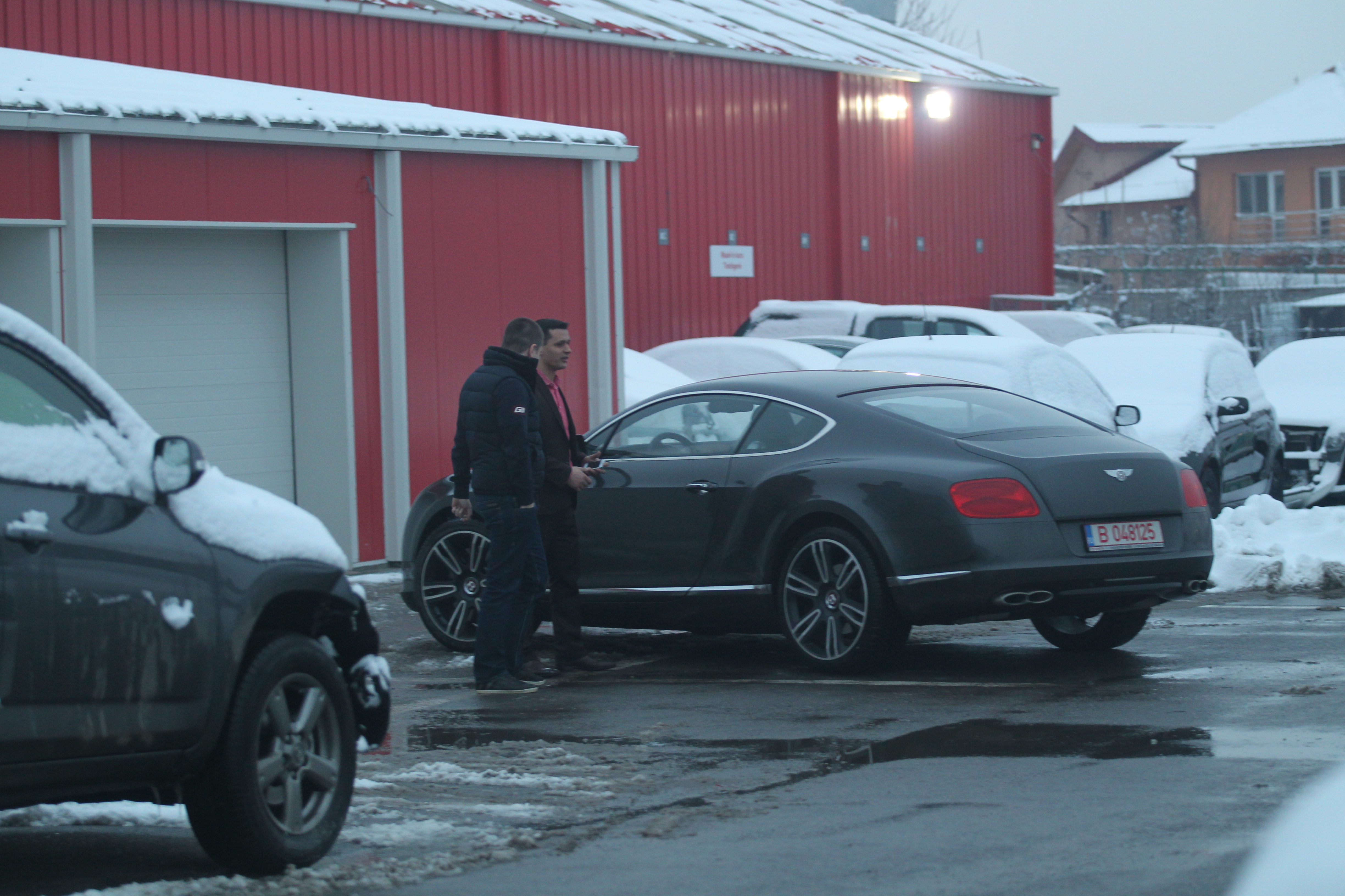 Tanarul ii explica angajatului ce problema are masina