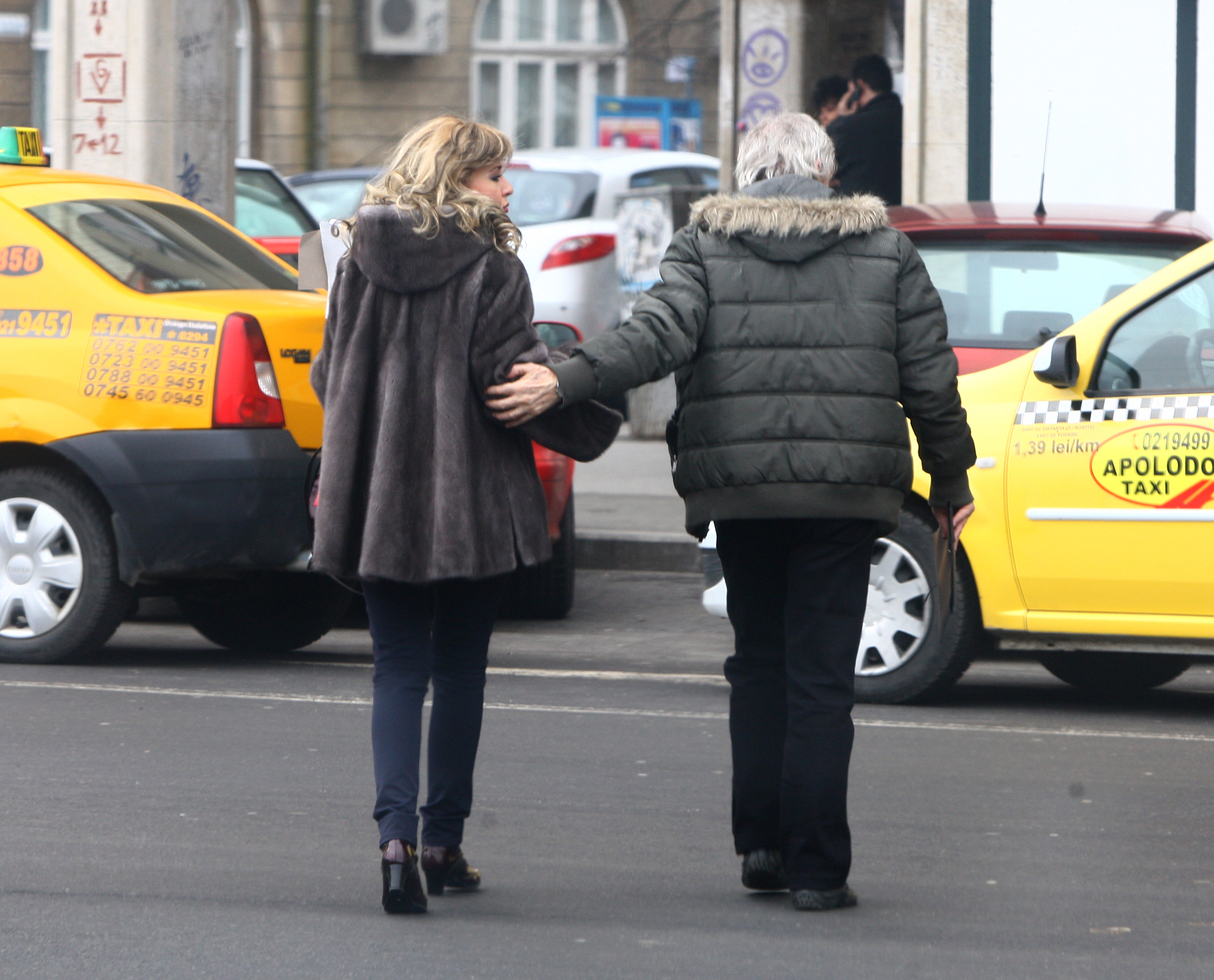 Protector, ca un tata adevarat, Stefan Velniciuc o tine de brat la Alexandra, in momentul in care traverseaza
