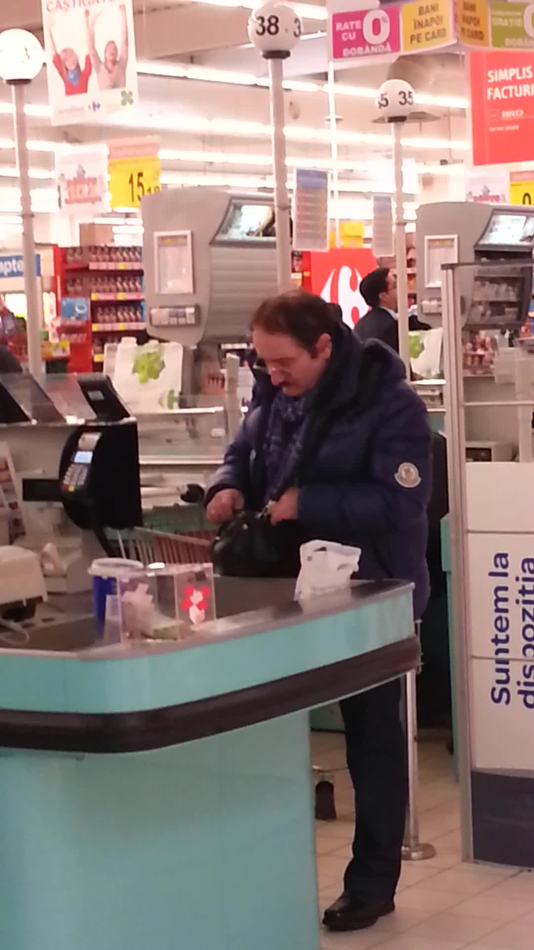 Actorul cauta atent banii pentru a plati ceea ce a cumparat