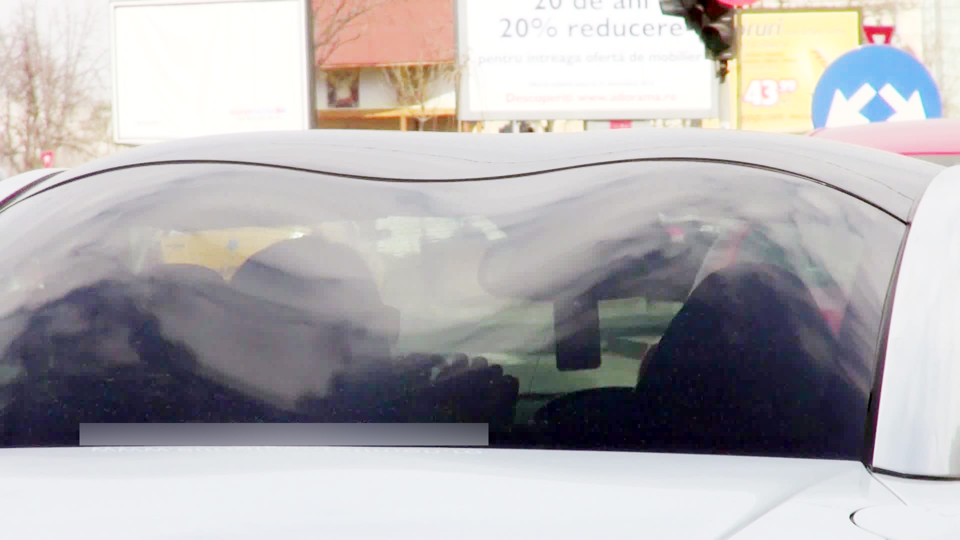 Bruneta profita de culoarea rosie a semaforului pentru a se machia in oglinda