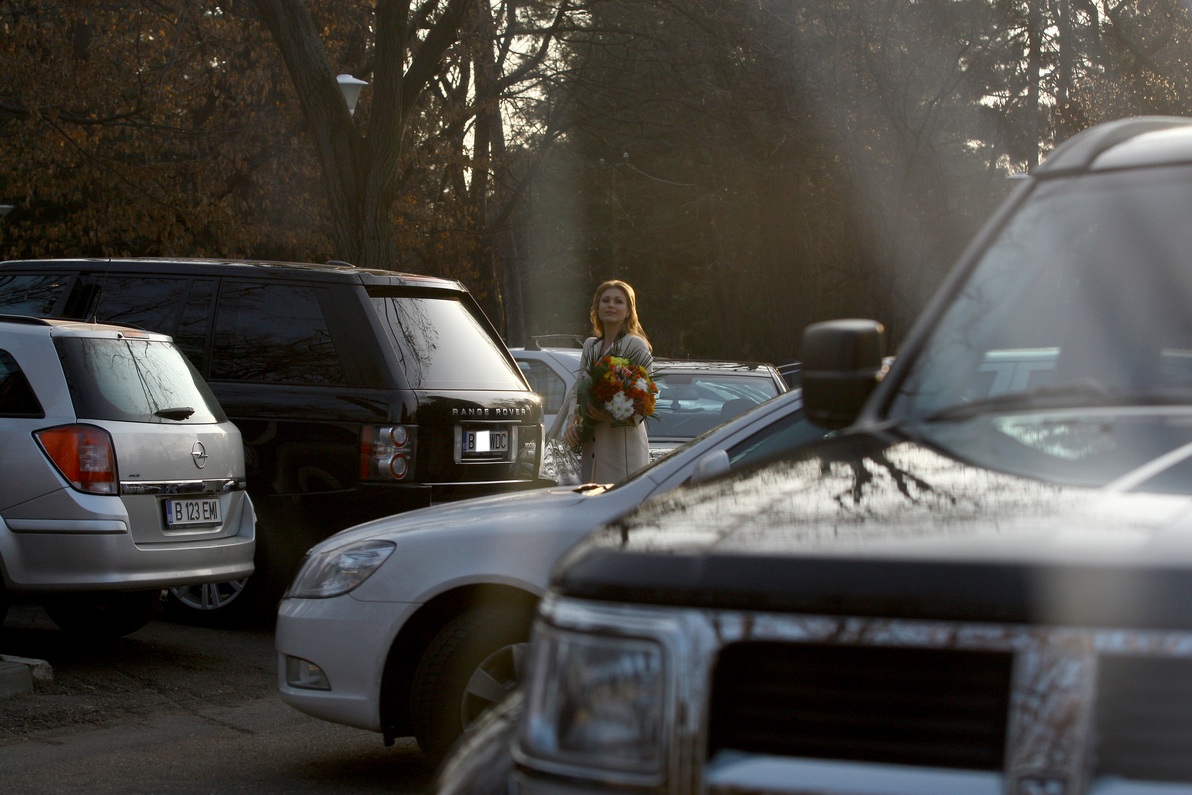 Cantareata iese din masina cu un buchet de flori in brate