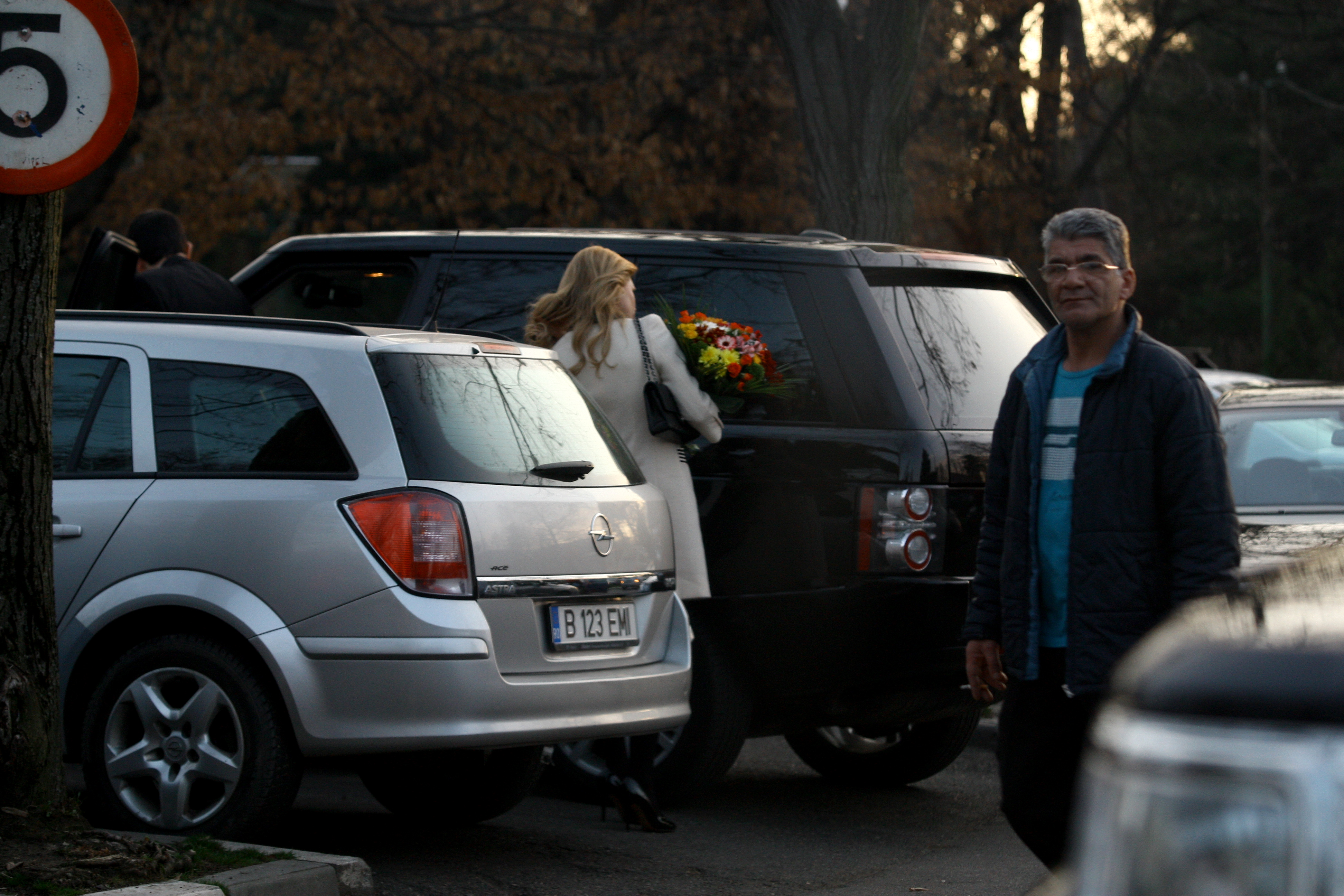 Inainte de a intra in resturant, blonda isi aranjeaza parul in geamul masinii