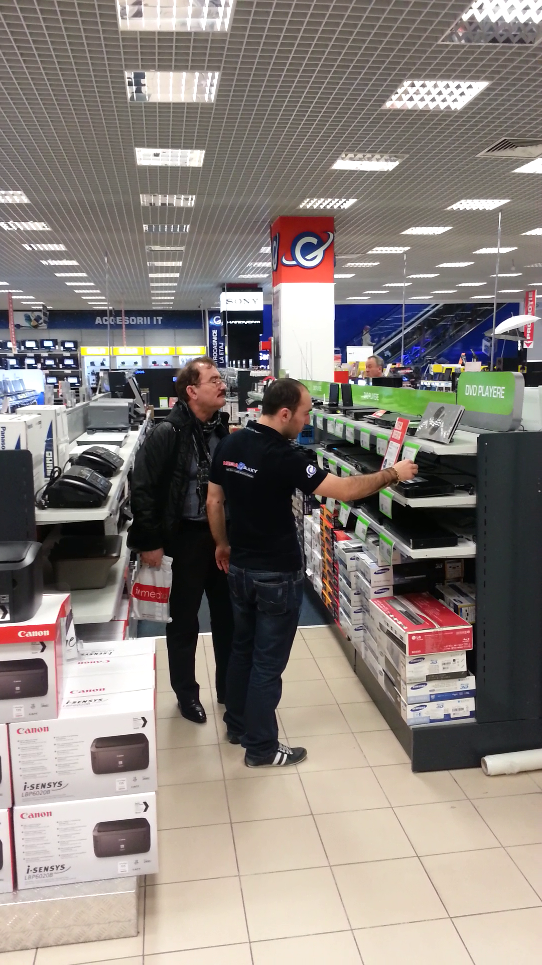 Barbatul cere ajutorul unui angajat al magazinului de electronice