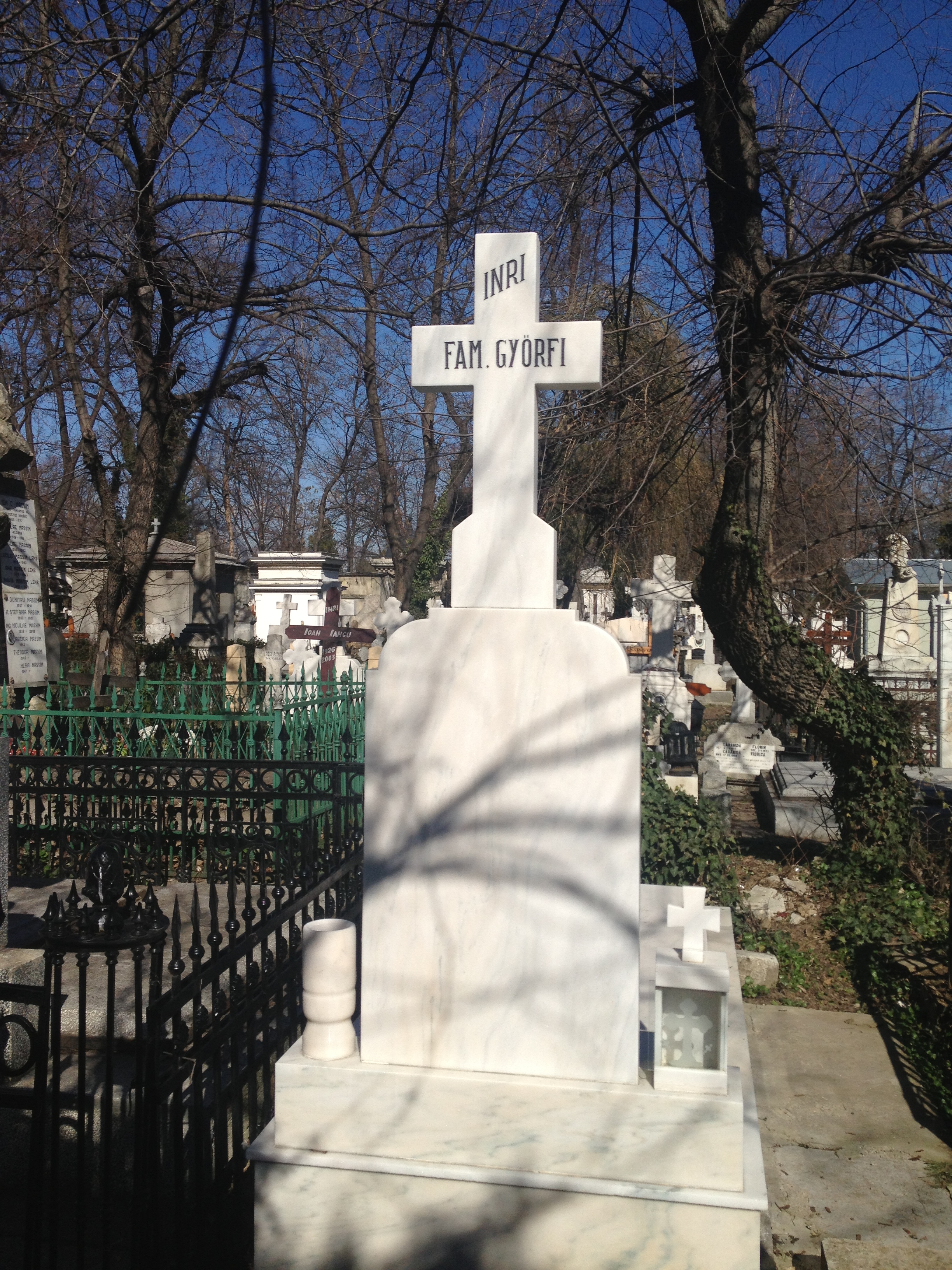 Pe spatele crucii impunatoare din marmura alba sta scris cu litere de-o schioapa 