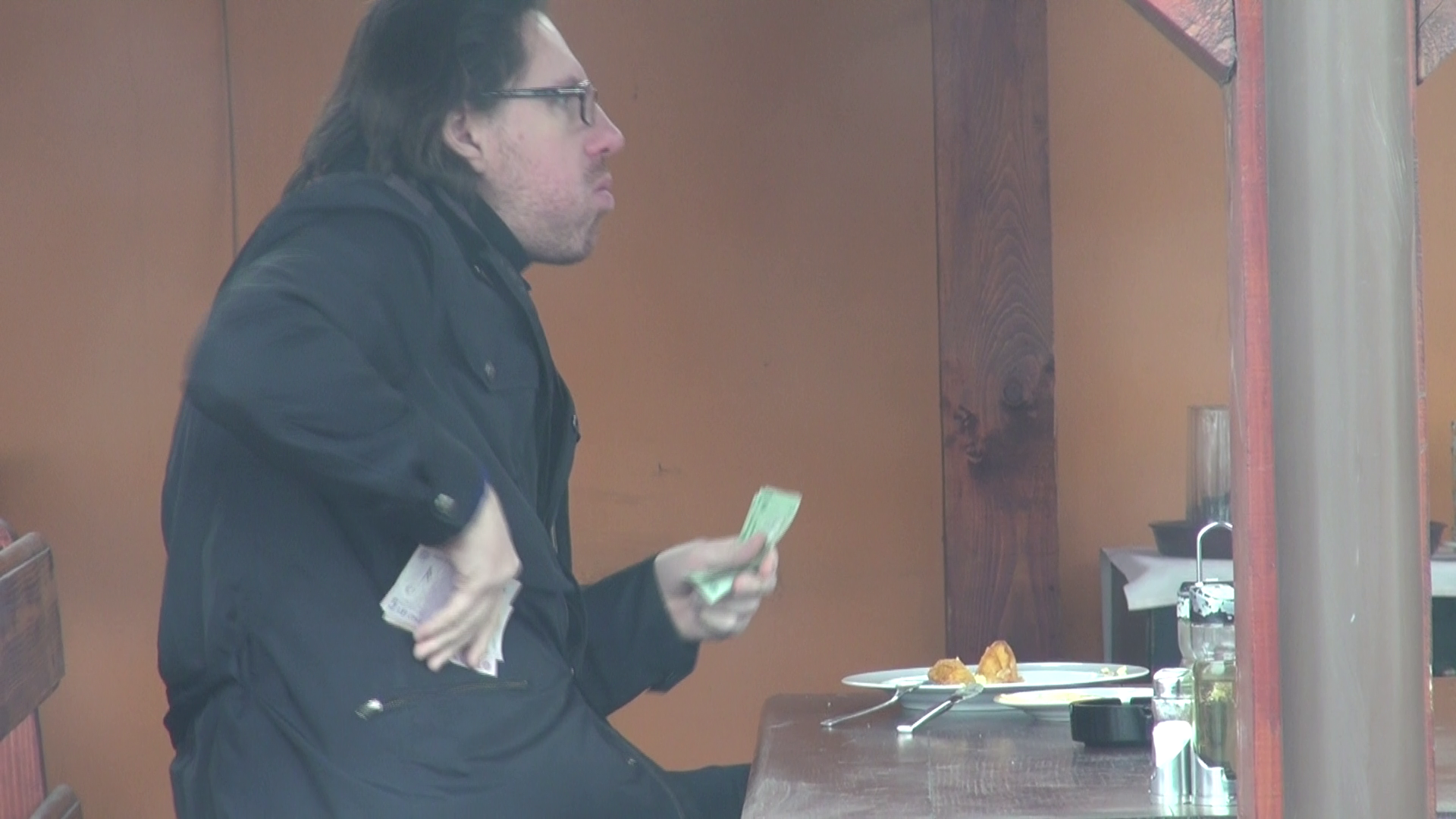 Dupa ce s-a asigurat ca a primit restul corect, naistul baga banii cu valoare mare intr-un buzunar