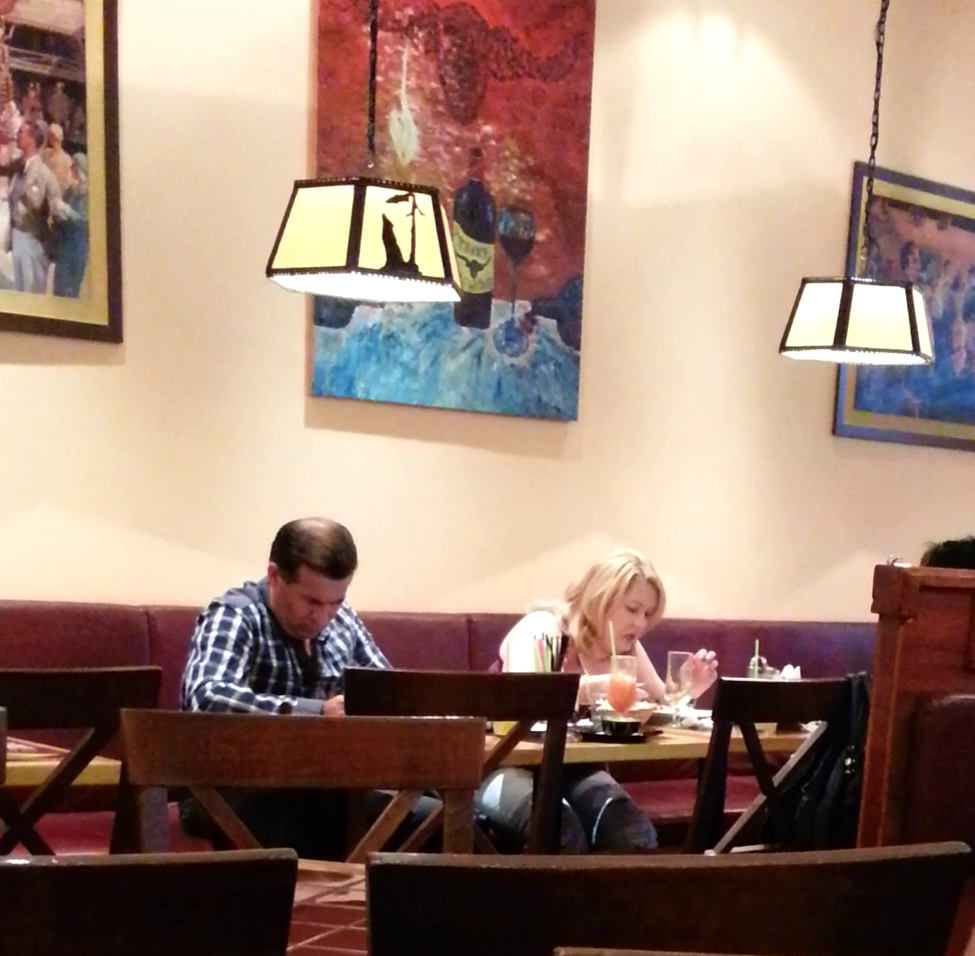 Cantareata mananca de zor, in timp ce sotul ei priveste catre telefonul mobil