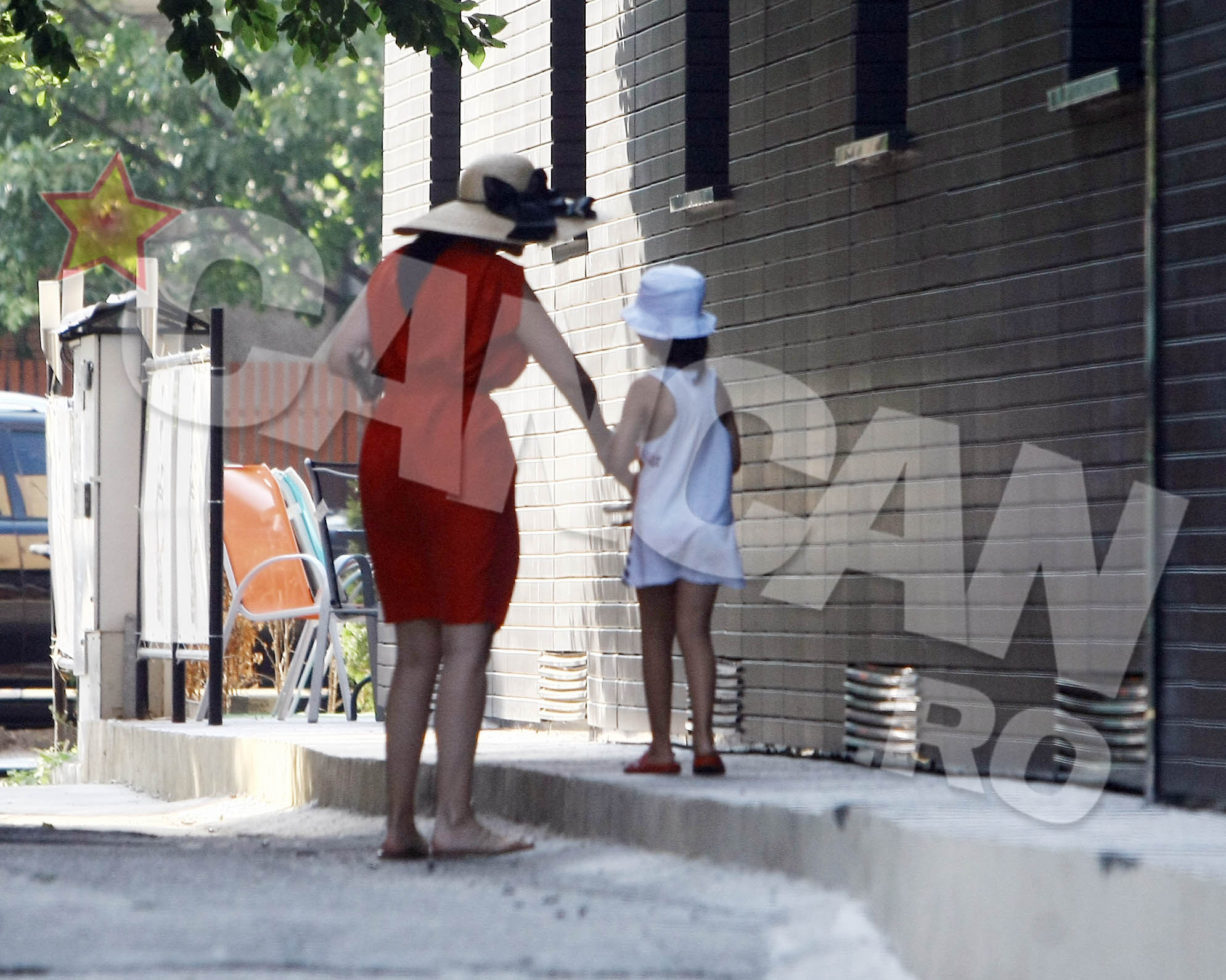 Andreea o ia pe fiica ei de mana pentru a intra impreuna in scara blocului