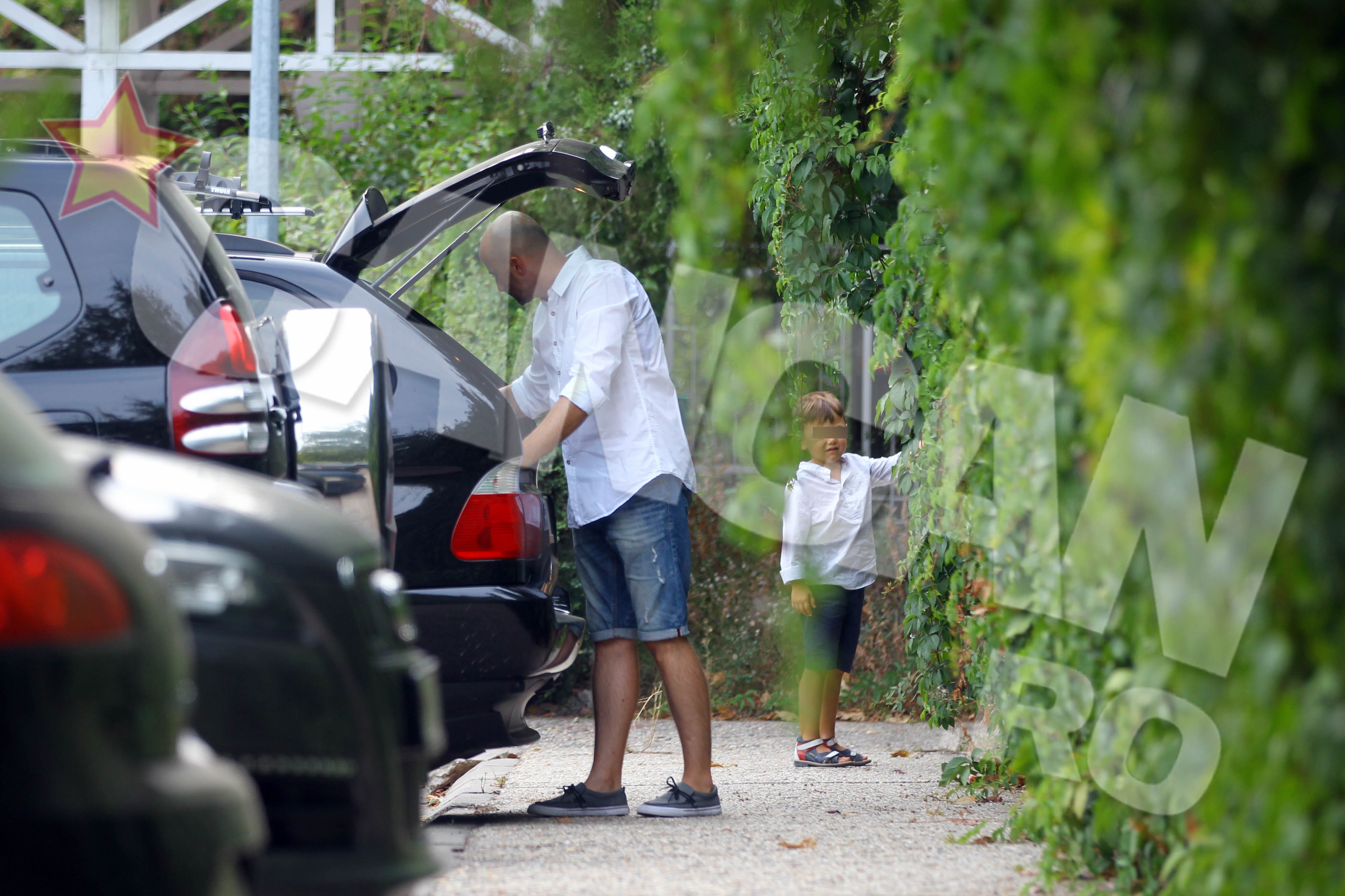 Artistul scoate ceva din portbagajul masinii insa arunca cate o privire si la copii