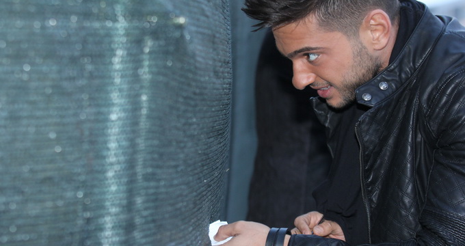 Dorian se chinuie sa bage biletelul in gaura din gard