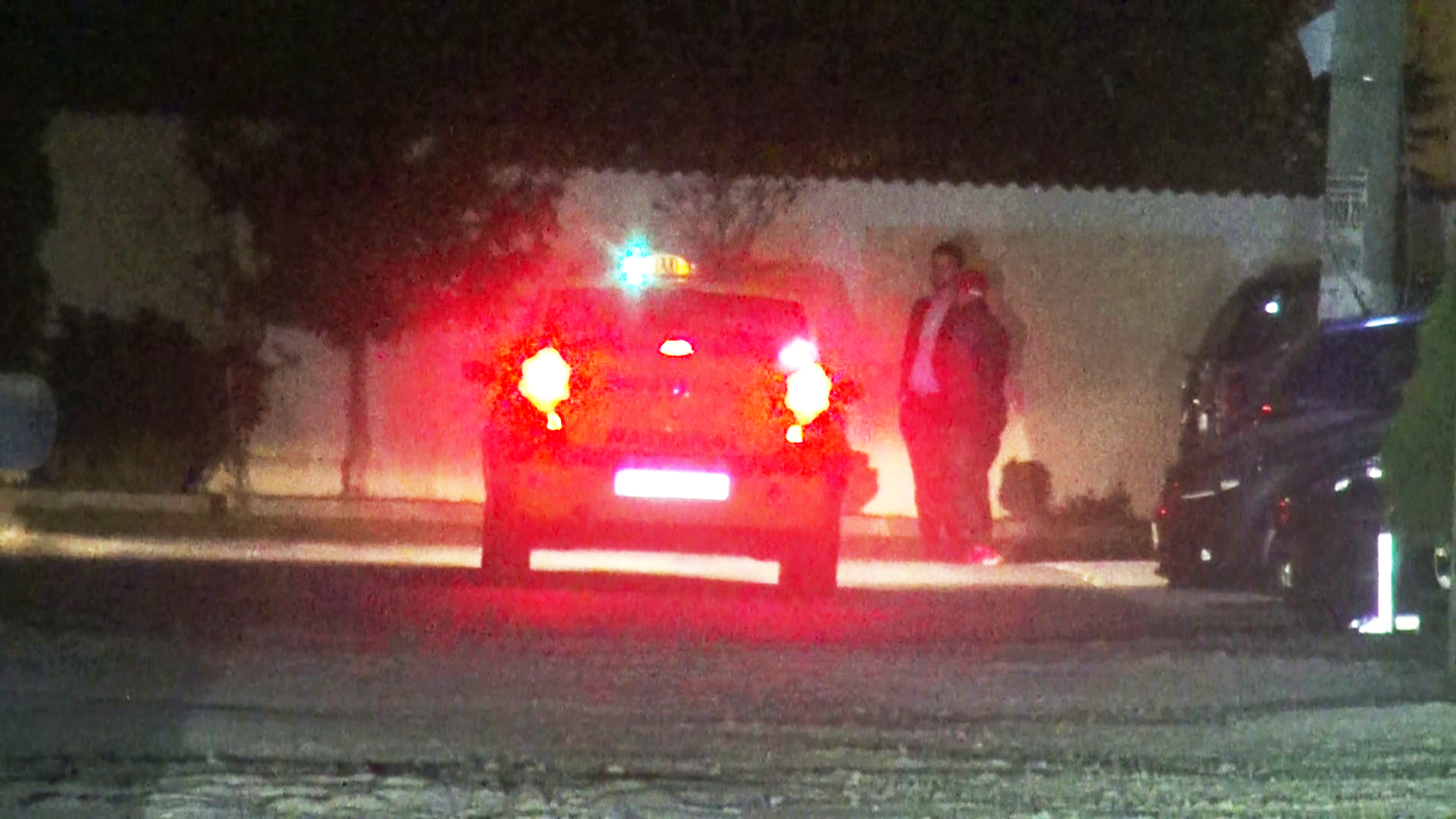 Cei doi barbati ies in strada pentru a astepta un taxi