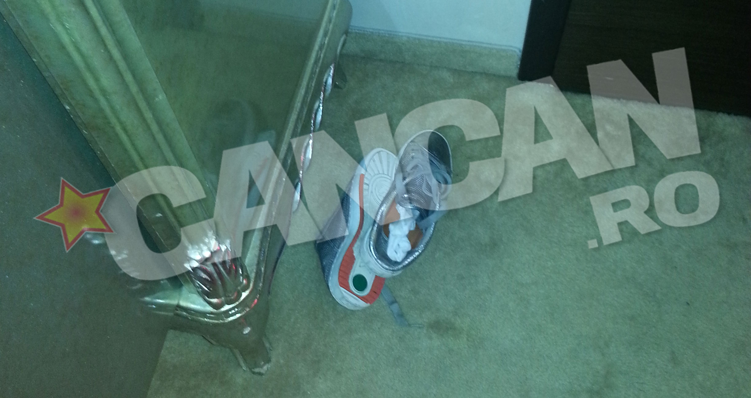 Intr-un colt al camerei era aruncata o pereche de pantofi sport barbatesti