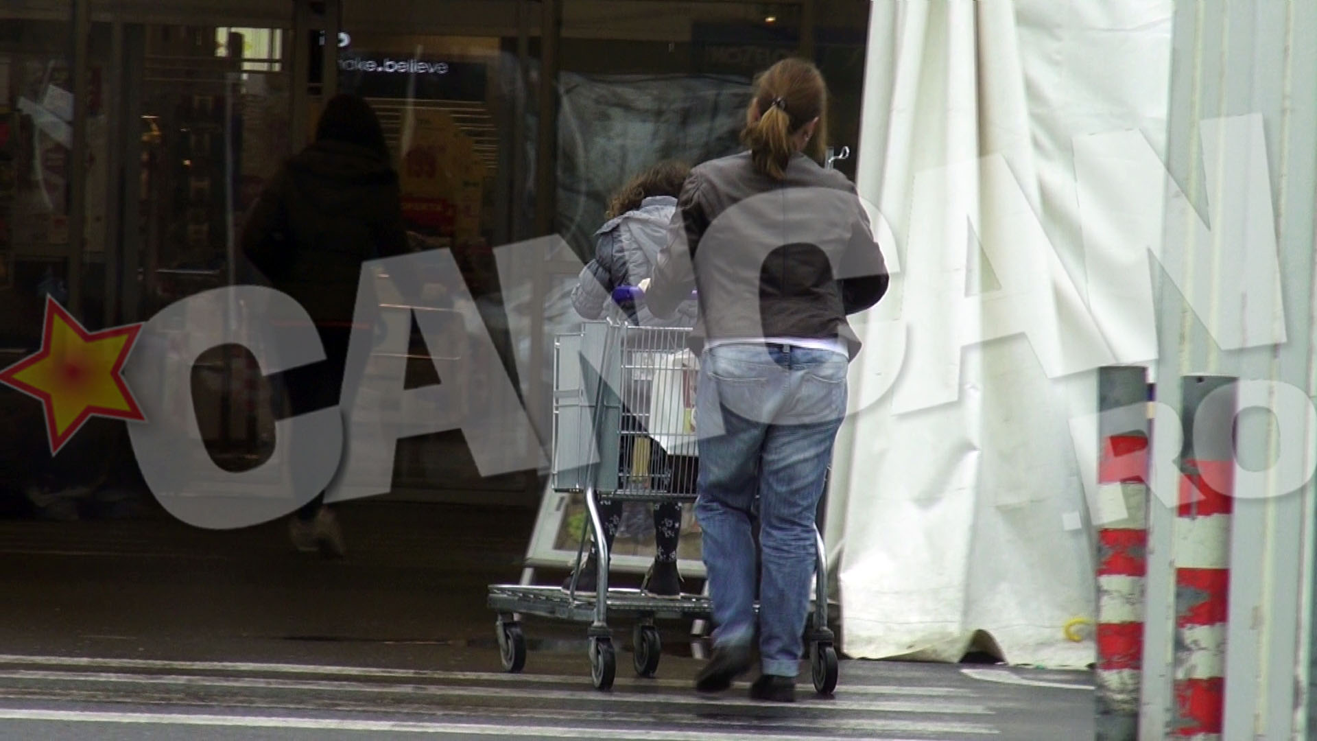 Cantareata isi pune fiica in caruciorul pentru cumparaturi si intra in supermarket