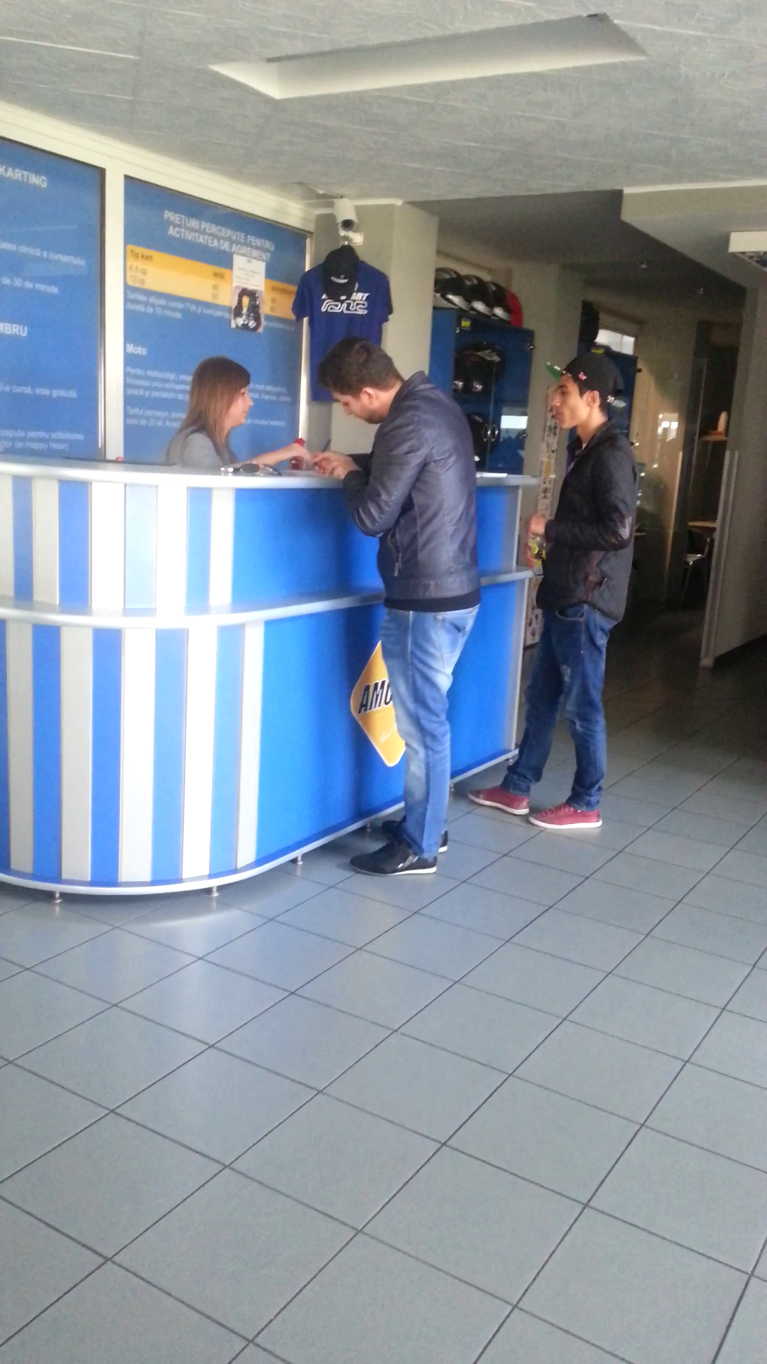 Cei doi asteapta la ghiseu sa inchirieze castile de protectie si sa plateasca pentru curse