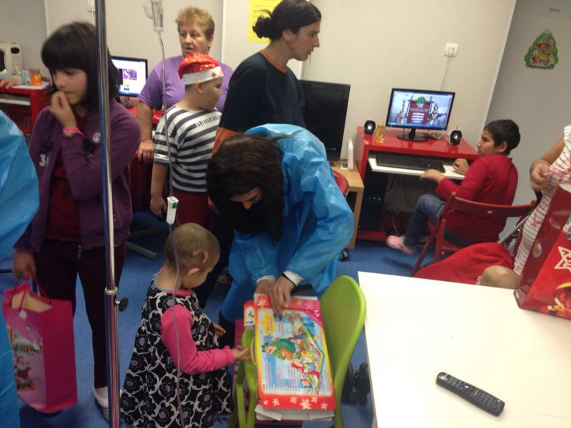 Larisa o ajuta pe o fetita sa deschida cadoul