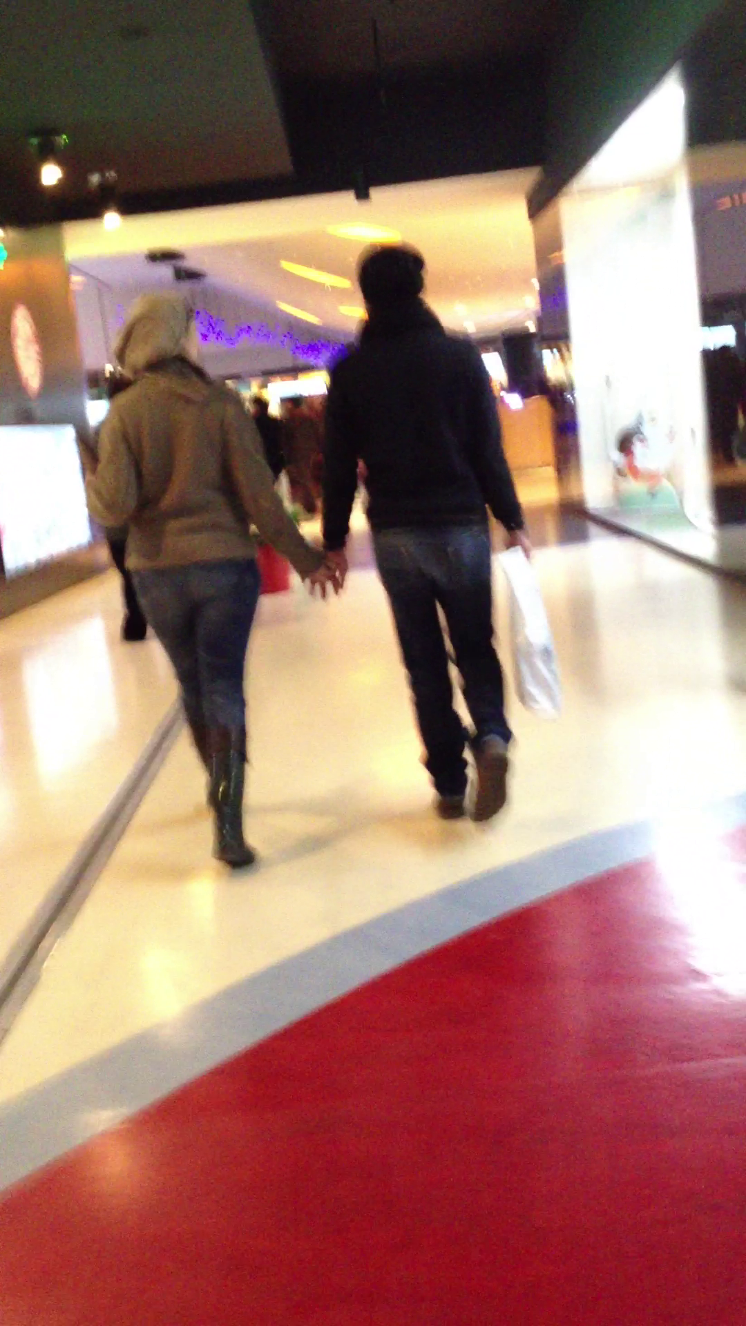 Ca niste adolescenti, cei doi indragostiti se plimba prin mall tinandu-se de mana