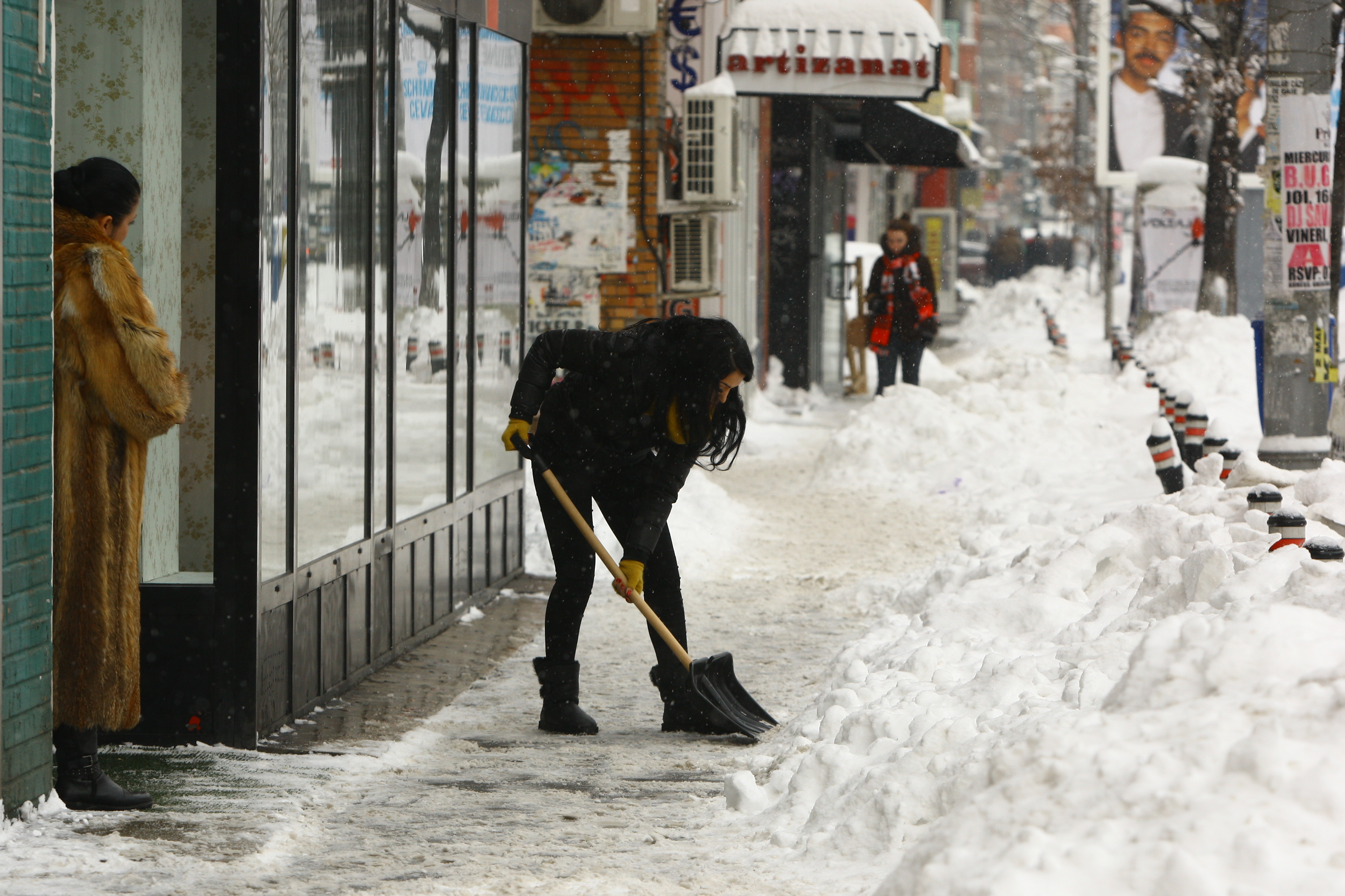 Bruneta a dat cu lopata zapada din fata magazinului sau
