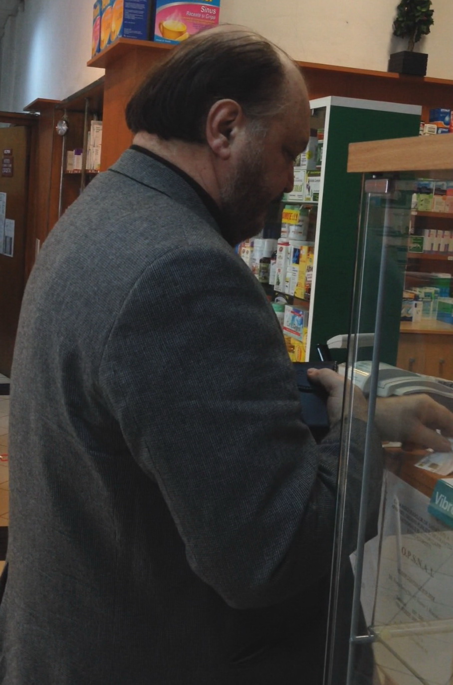 Victor Socaciu asteapta ca farmacista sa-i dea medicamentele pe care i le-a cerut