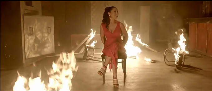 In clip, Andra apare legata la maini, intr-o camera in flacari