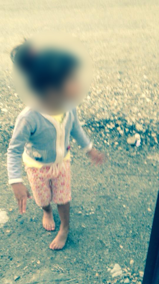 Fetita a iesit desculta pe o strada neasfaltata