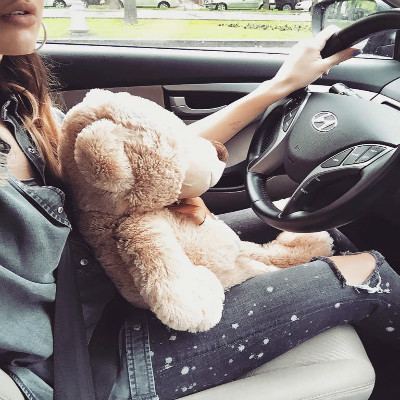 Lidia Buble ţine un urs de pluş în braţe când şofează.
