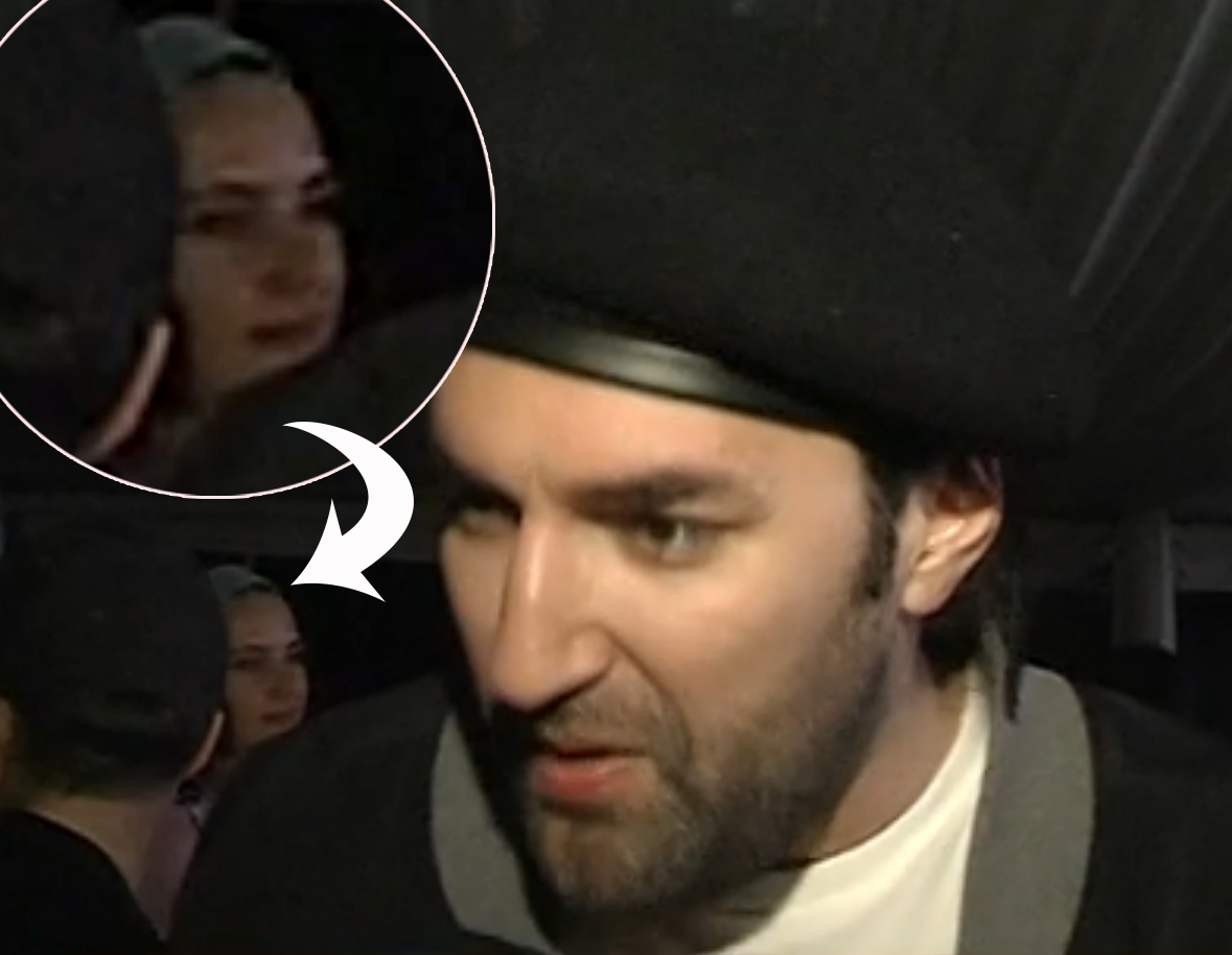 Olivia se afla în spatele lui Smiley, în momentul când artistul acorda un interviu la un eveniment.