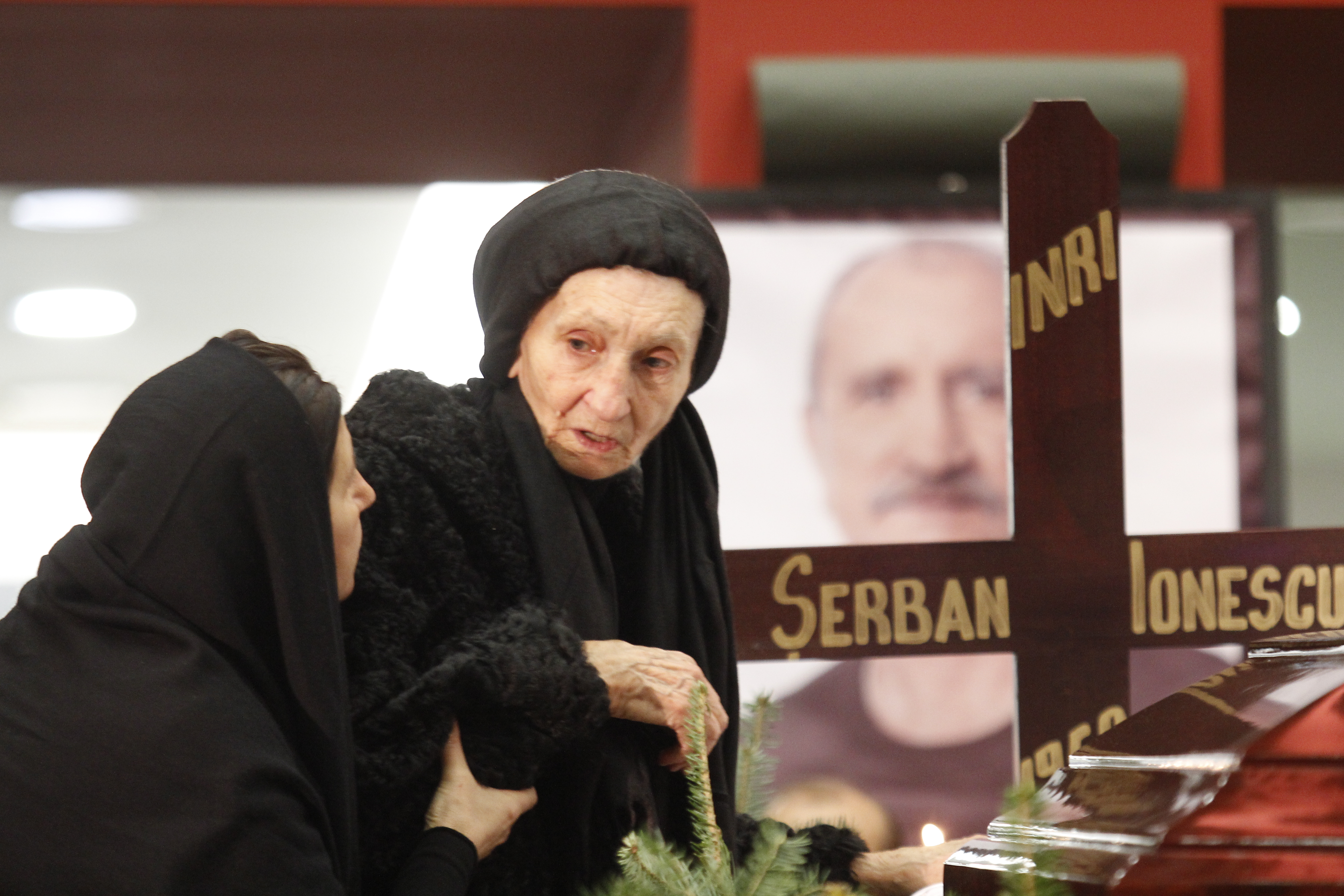 Magda Catone isi sprijina soacra, in timp ce-si plangeau amandoua sotul, respectiv fiul