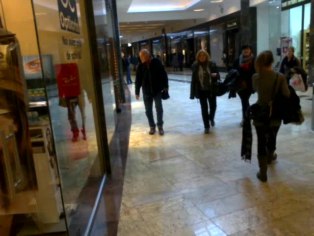 Cornel Patrichi trage cu ochiul la vitrine, sotia sa se indreapta glont spre iesirea din mall