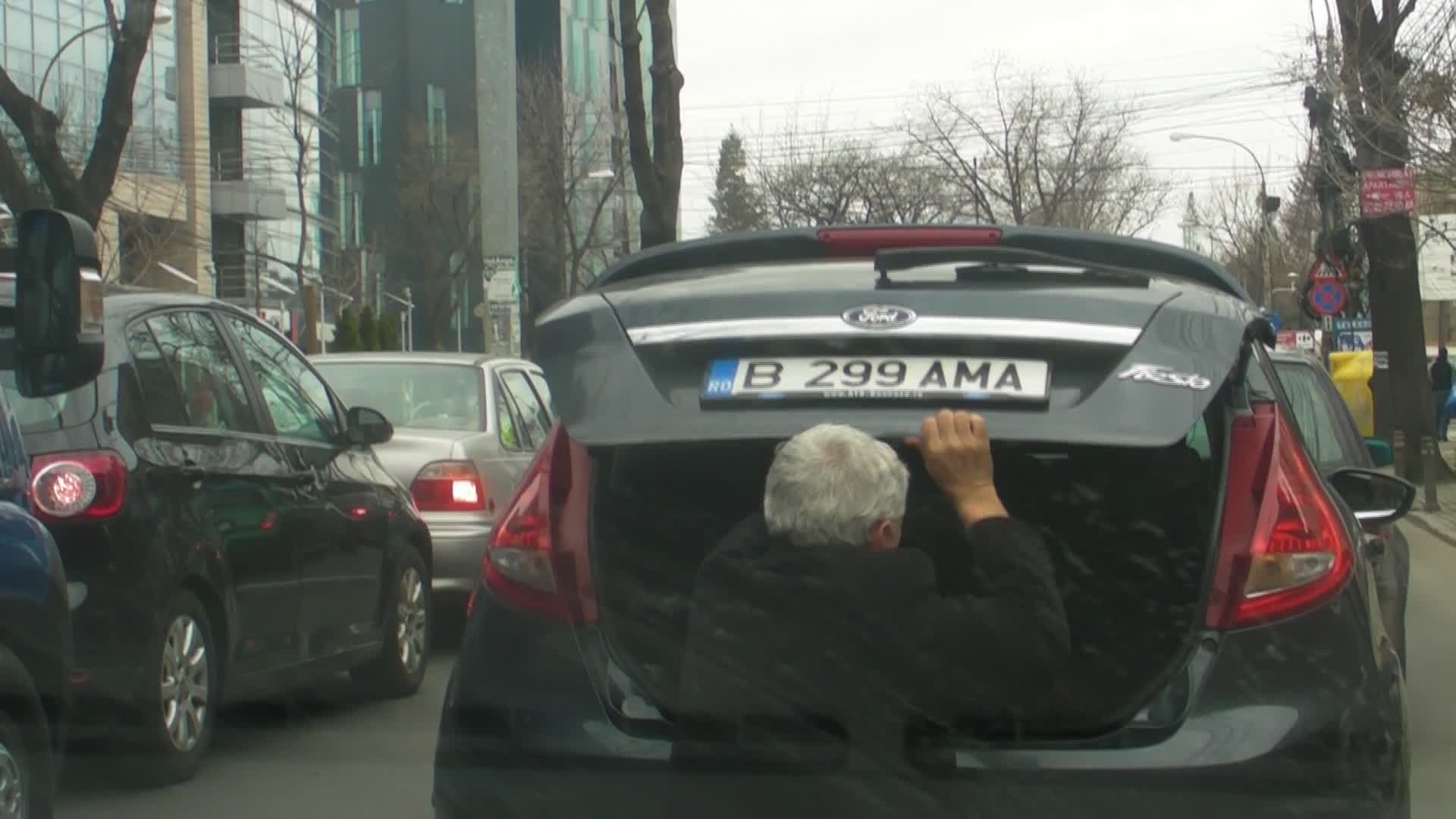 Pentru ca usa portbagajului nu s-a inchis bine, actorul coboara din masina la semafor si mai aranjaza o data bagajele