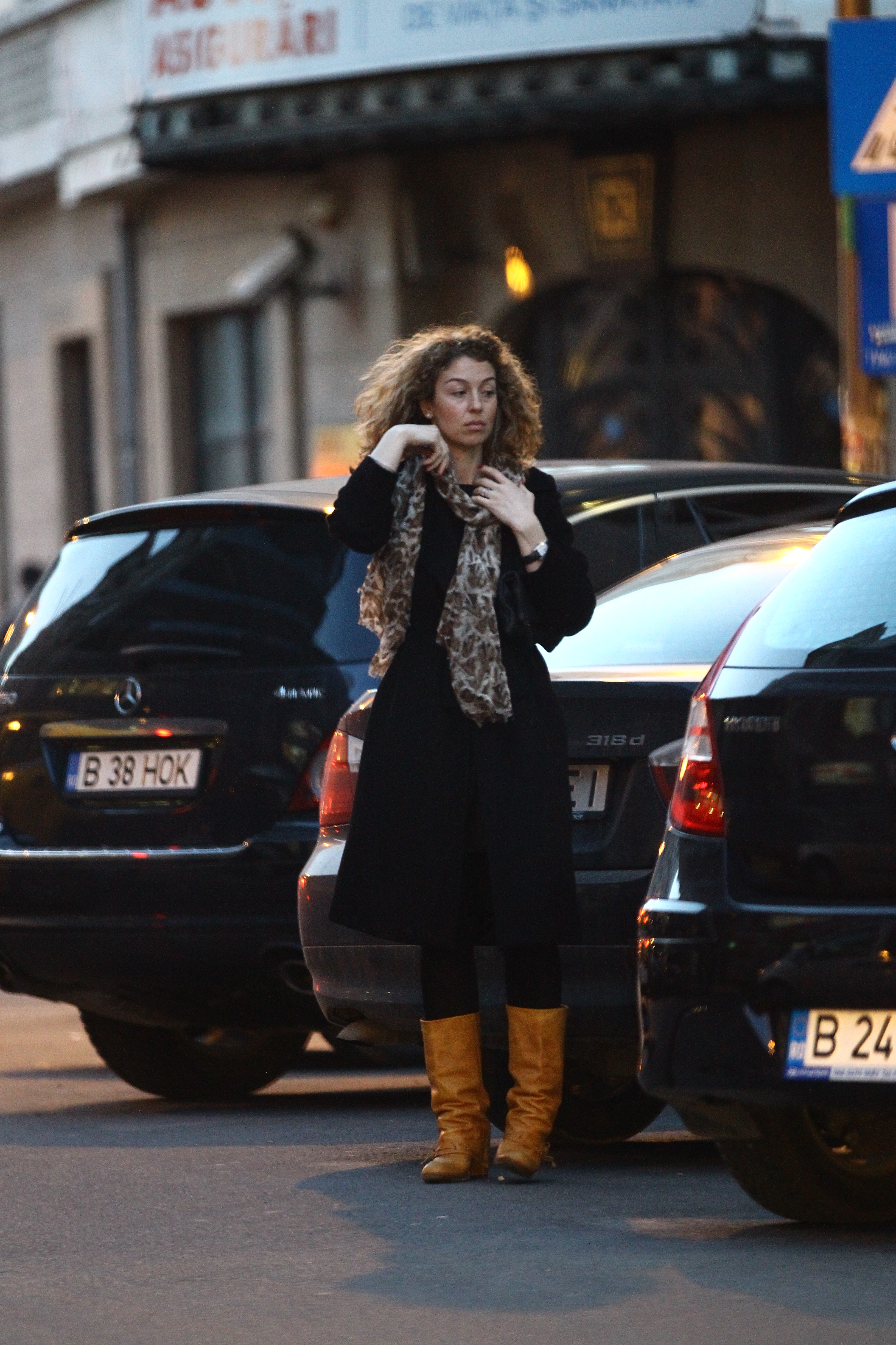 Elena pare macinata de ganduri si isi pune cu gesturi mecanice esarfa