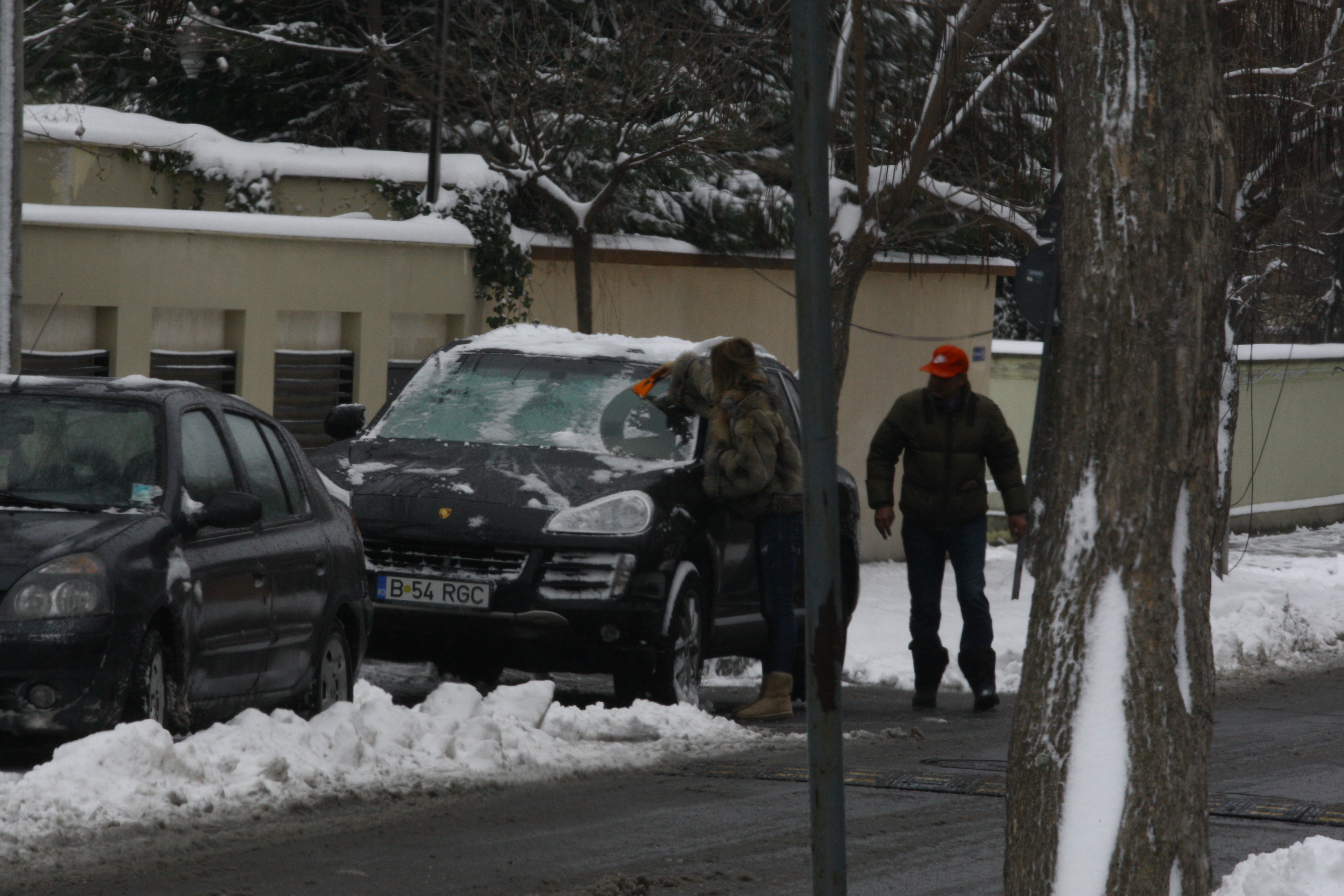 ...se apuca sa-l ajute pe angajat la zapada, desi e imbracata in haina de blana