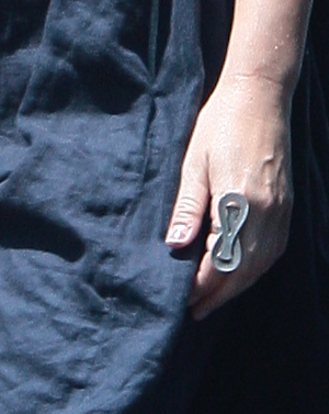 Blonda poarta pe deget un inel din argint care ii acopera jumatate din deget