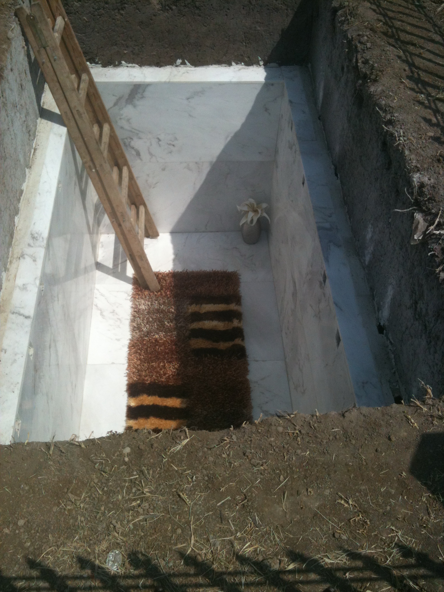 Cu putin timp inainte ca milionarul sa fie inmormantat, in groapa a fost pus un covor, dar si o vaza cu flori