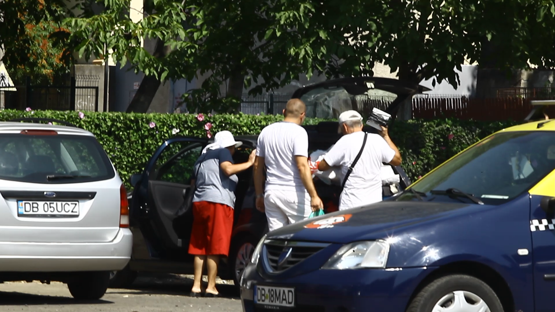 Socrii profesoarei aranjeaza bagajele voluminoase in portbagajul neincapator