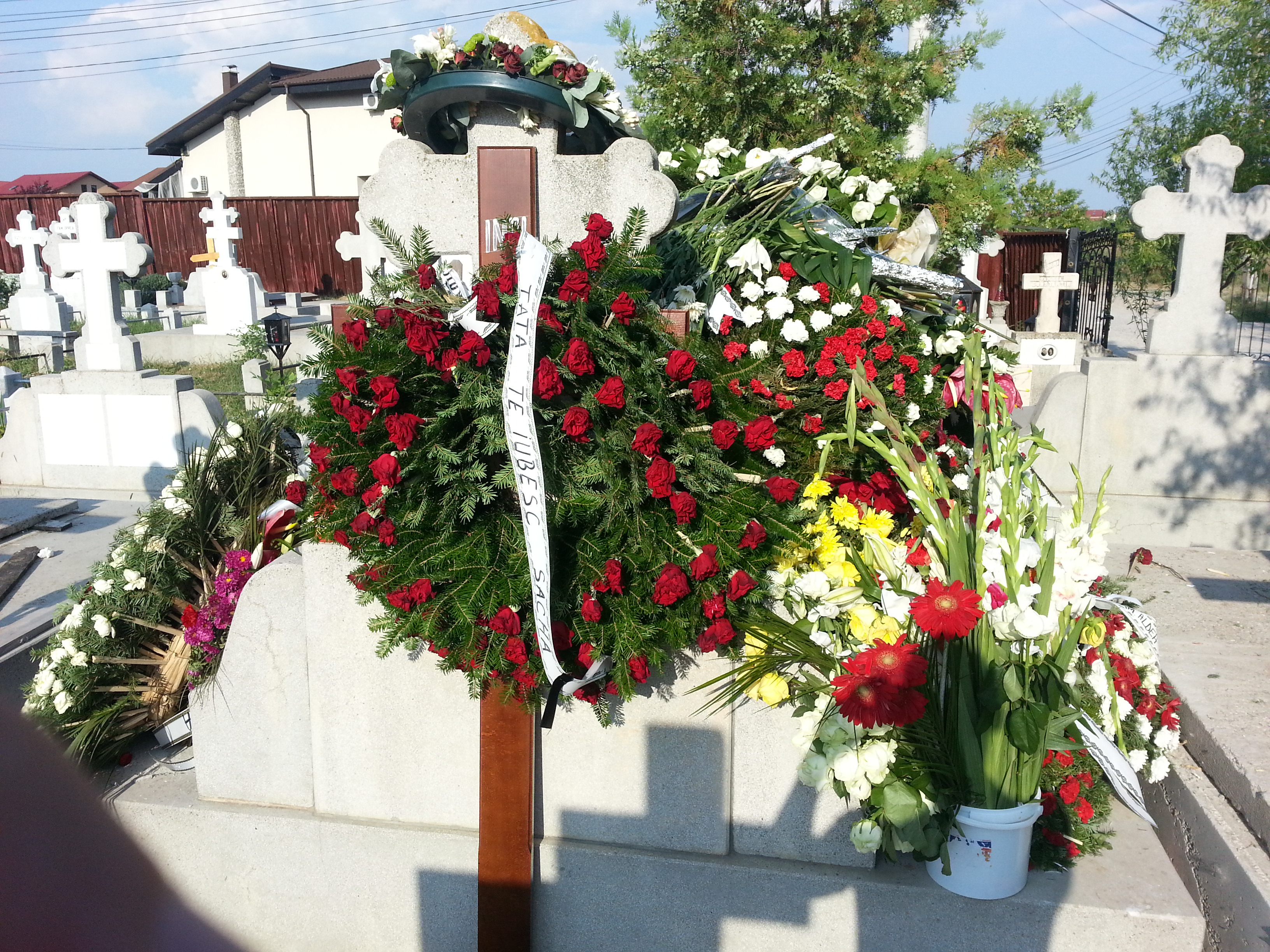 O multime de coroane au fost puse pe mormantul milionarului