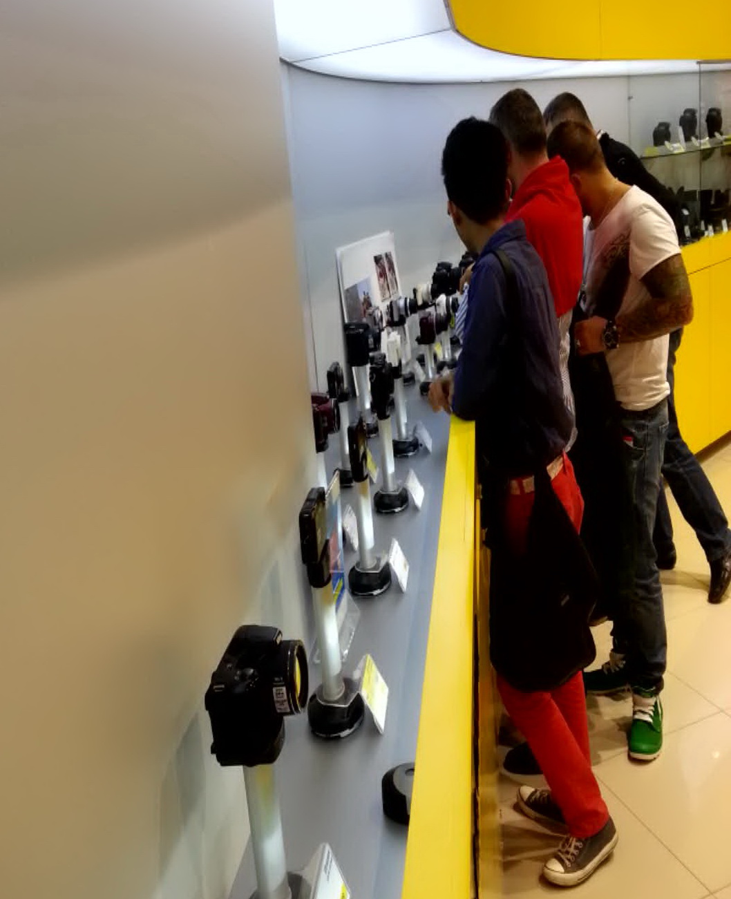 Nini, Alexandru si Traian studiaza cu atentie camerele foto