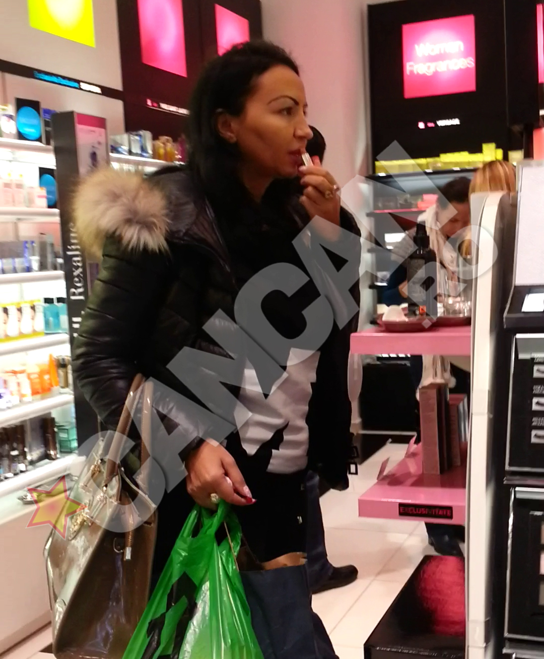 Fosta iubita a manelistului nici nu se sinchiseste de faptul ca ar putea fi observata si desface un ruj, dandu-se cu el pe buze. Apoi, inchide capacul si il pune din nou pe raft