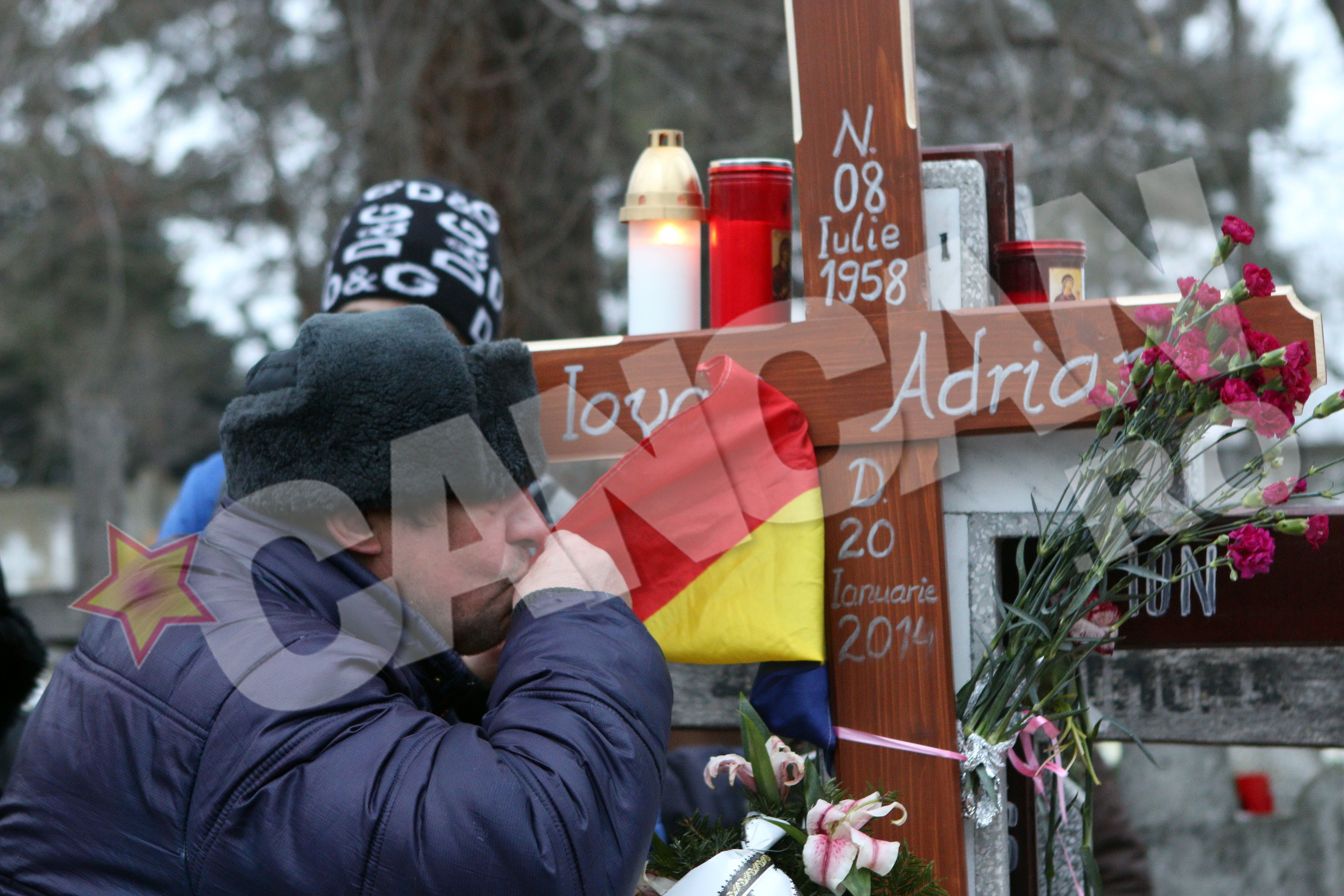 Un prieten al pilotului saruta plangand tricolorul