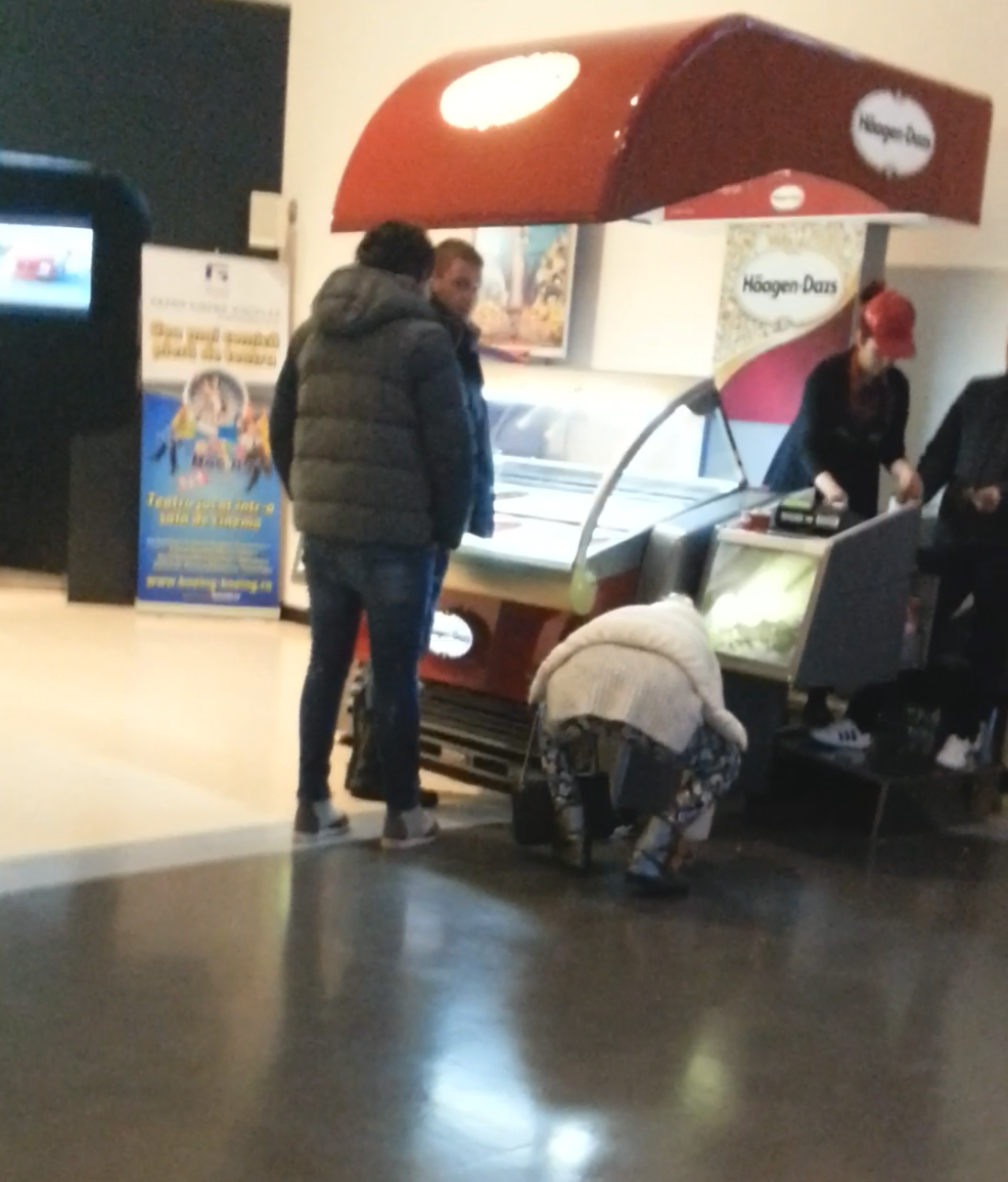 Ioana se apleaca cu greu sa ia de jos banii care i-au alunecat din mana