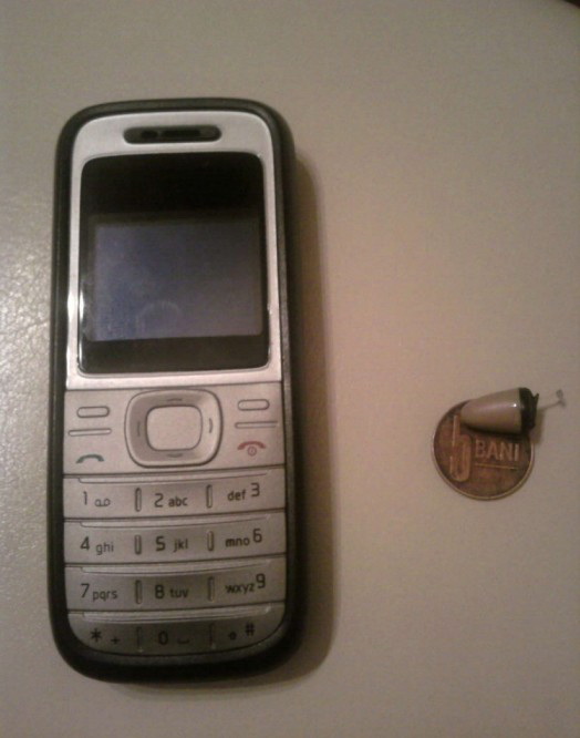 Casca se baga in ureche si se conecteaza la telefonul mobil prin bluetooth