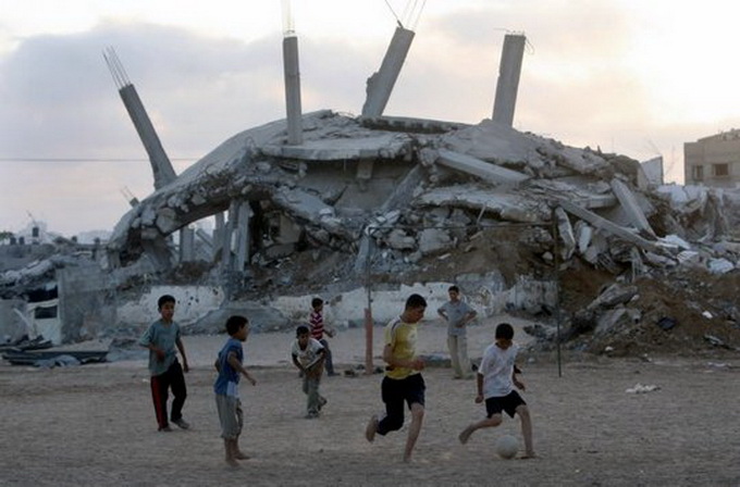 In Fasia Gaza, copiii joaca fotbal printre ruine