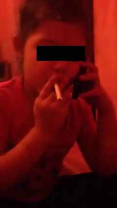 O fetita de cinci ani fumeaza si vorbeste la telefon, iar cineva o filmeaza