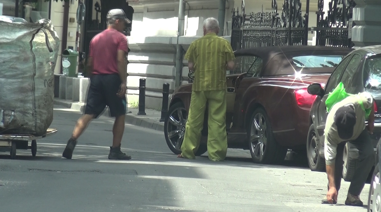 O poza cat o mie de cuvinte: un imens sac de gunoi, un cersetor aplecat dupa un chistoc de tigara si... un milionar excentric