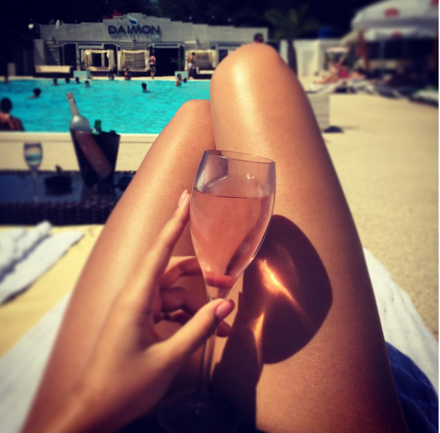 Bruneta si-a pus un pahar de sampanie intre picioare.