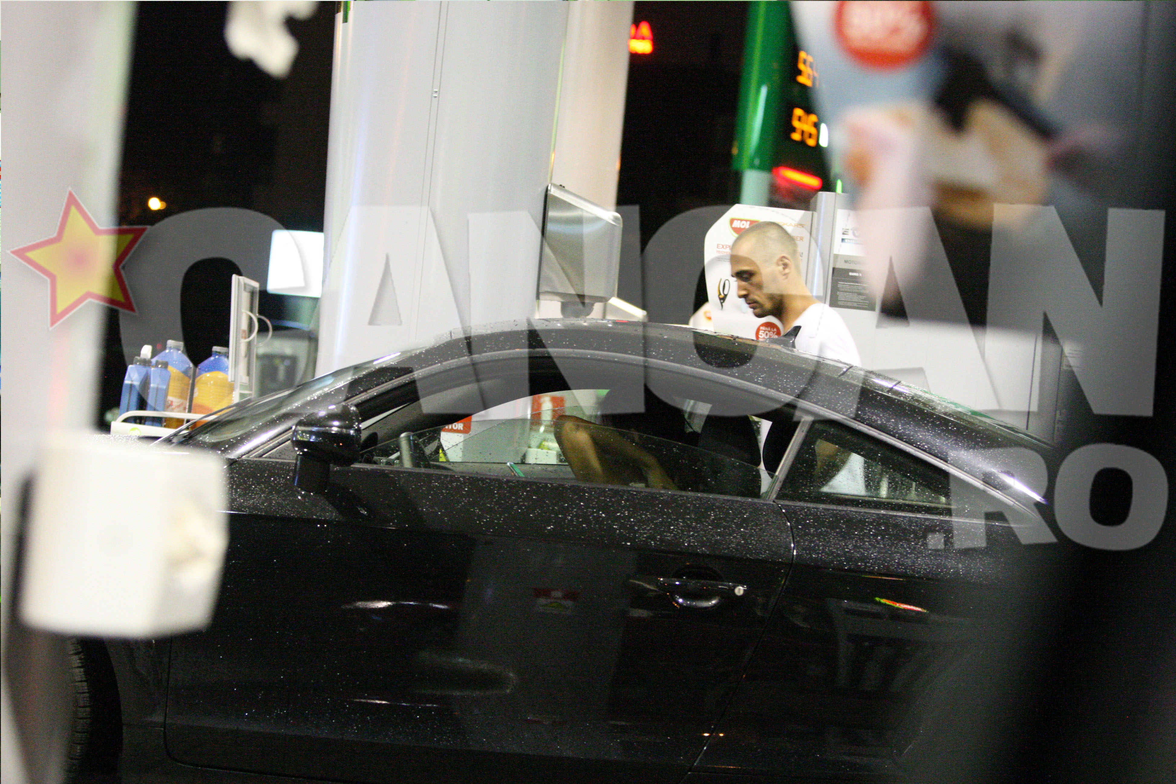 Burlacul in timp ce isi punea combustibil la masina.